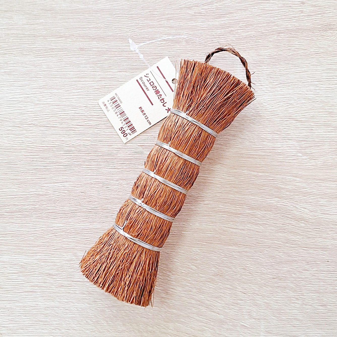 麻の小さな箒が白い背景にある。価格は税込599円と書かれたタグが付いている。