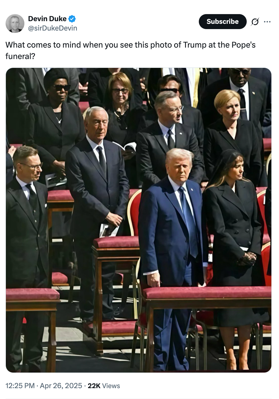 People, including a former U.S. President, stand respectfully at a formal event with a religious context, seating arranged in an outdoor setting