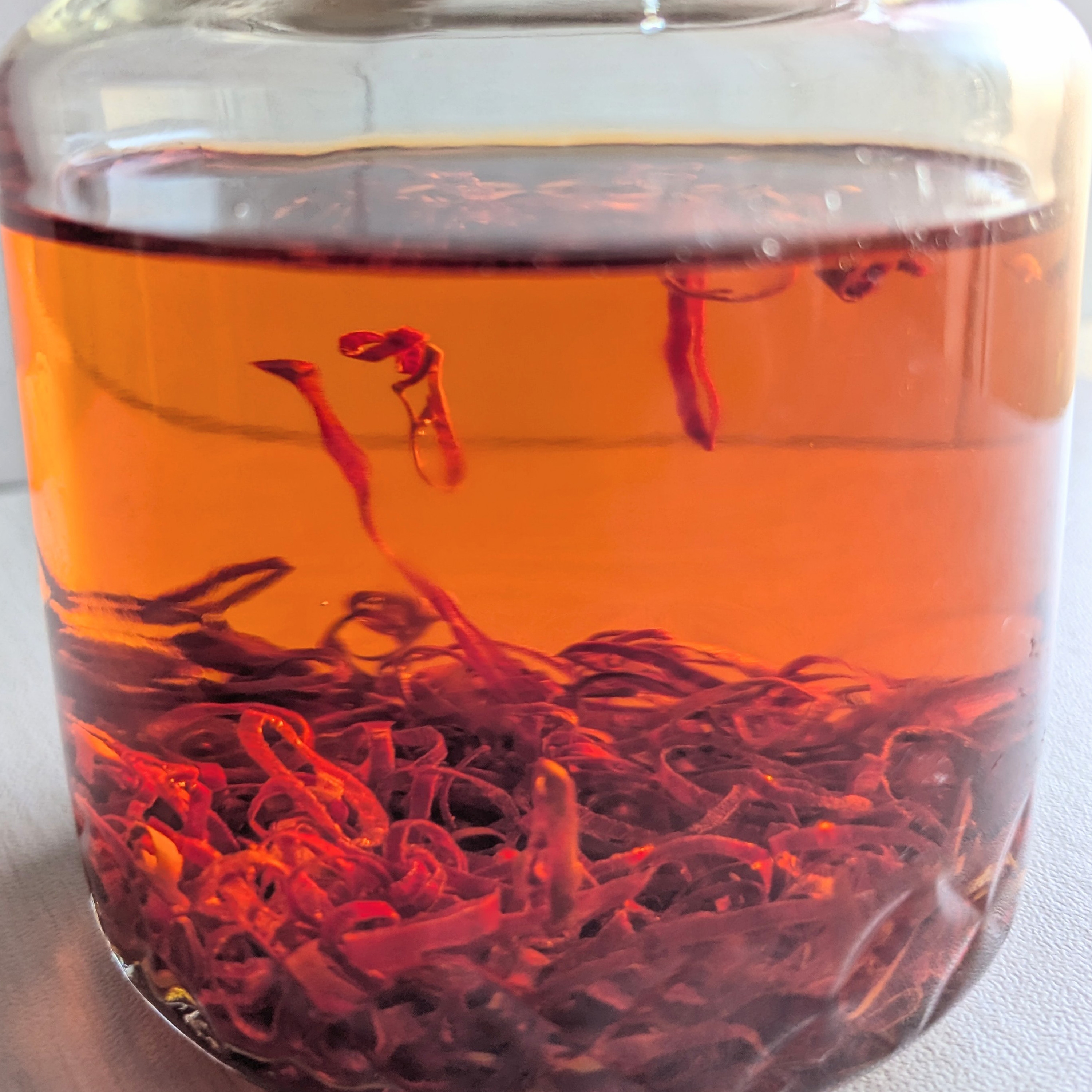 瓶に浸かっている赤い輪切り唐辛子。保存や研究に利用されている様子がうかがえる。