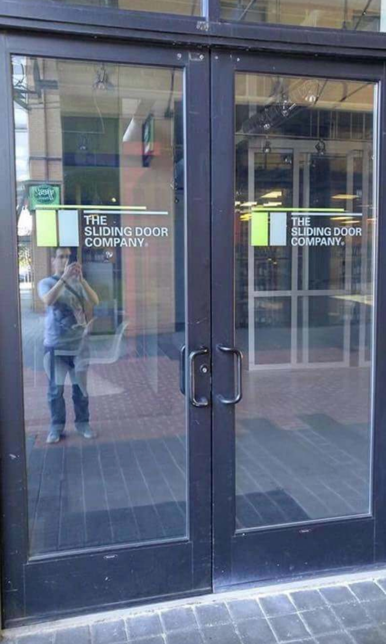 Storefront with a sign that reads "The Sliding Door Company" ironically featured on non-sliding glass doors