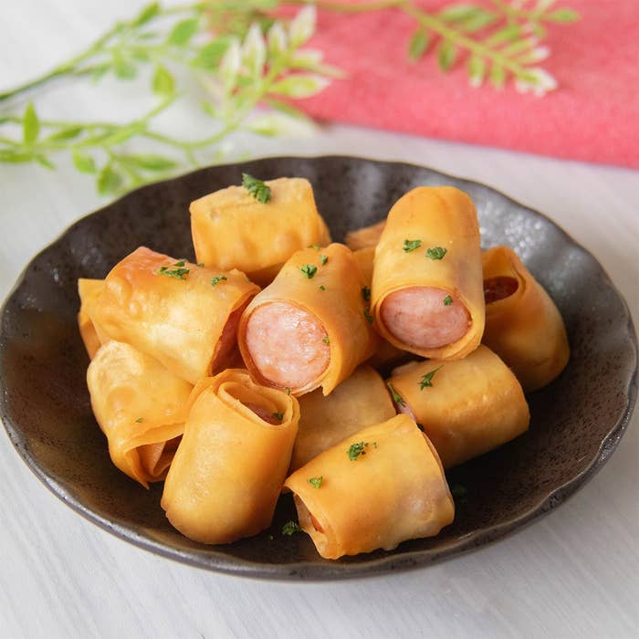 皿に盛られた、ソーセージにワンタンの皮を巻いて揚げた料理。