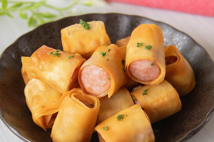 皿に盛られた、ソーセージにワンタンの皮を巻いて揚げた料理。