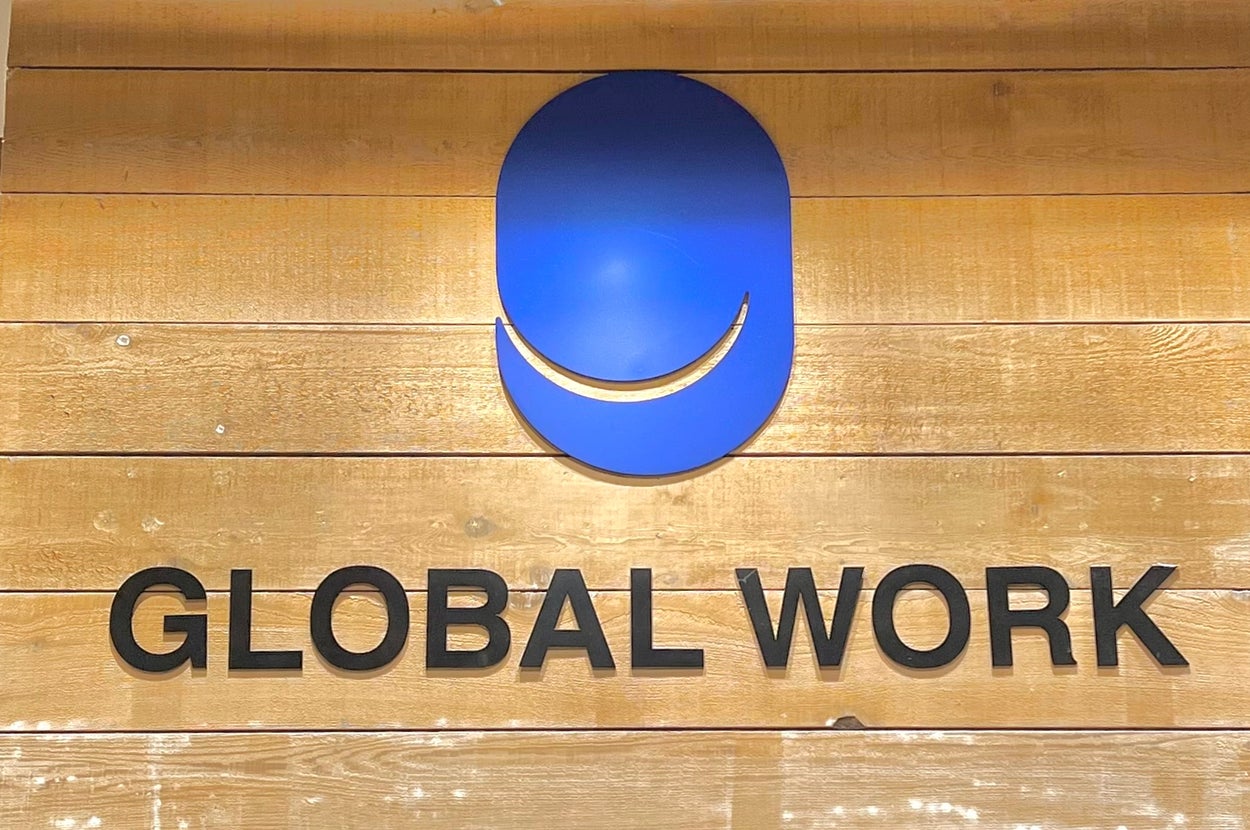 木の壁に「GLOBAL WORK」のロゴとテキストが表示されています。