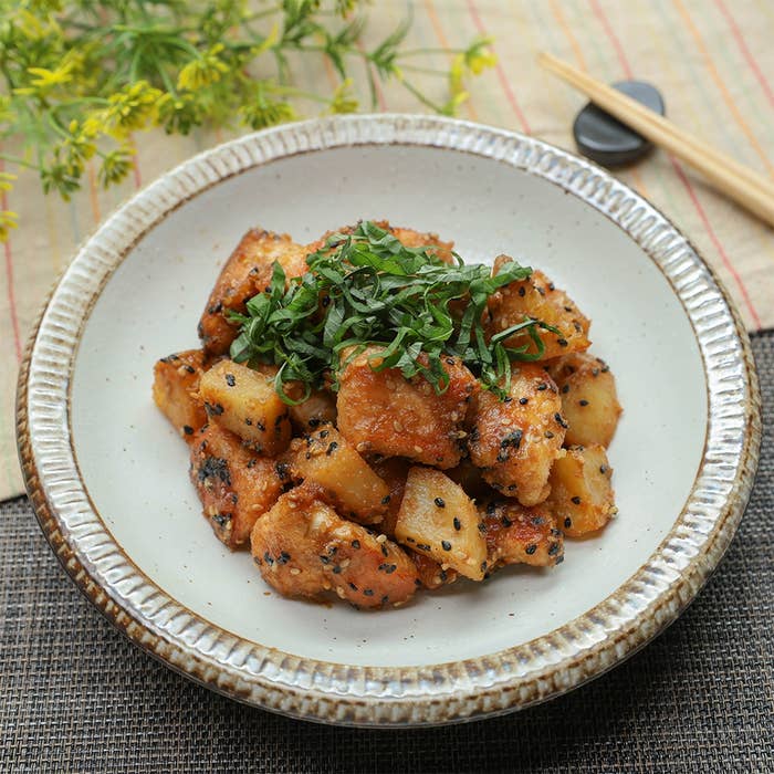 白い皿に盛られたじゃがいもと鶏むね肉のごまみそ和えの料理。上には刻んだ緑の大葉が添えられている。