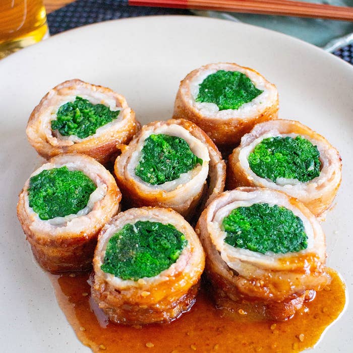 お皿に盛られた肉巻きほうれん草の料理。ソースがかかって美味しそうに見える。