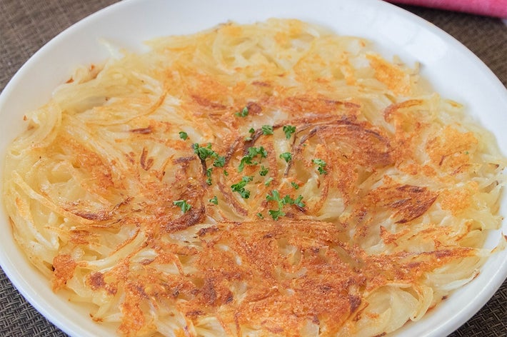 白い皿に盛られたカリカリのじゃがいもと玉ねぎのガレット。中央にパセリが散らされています。