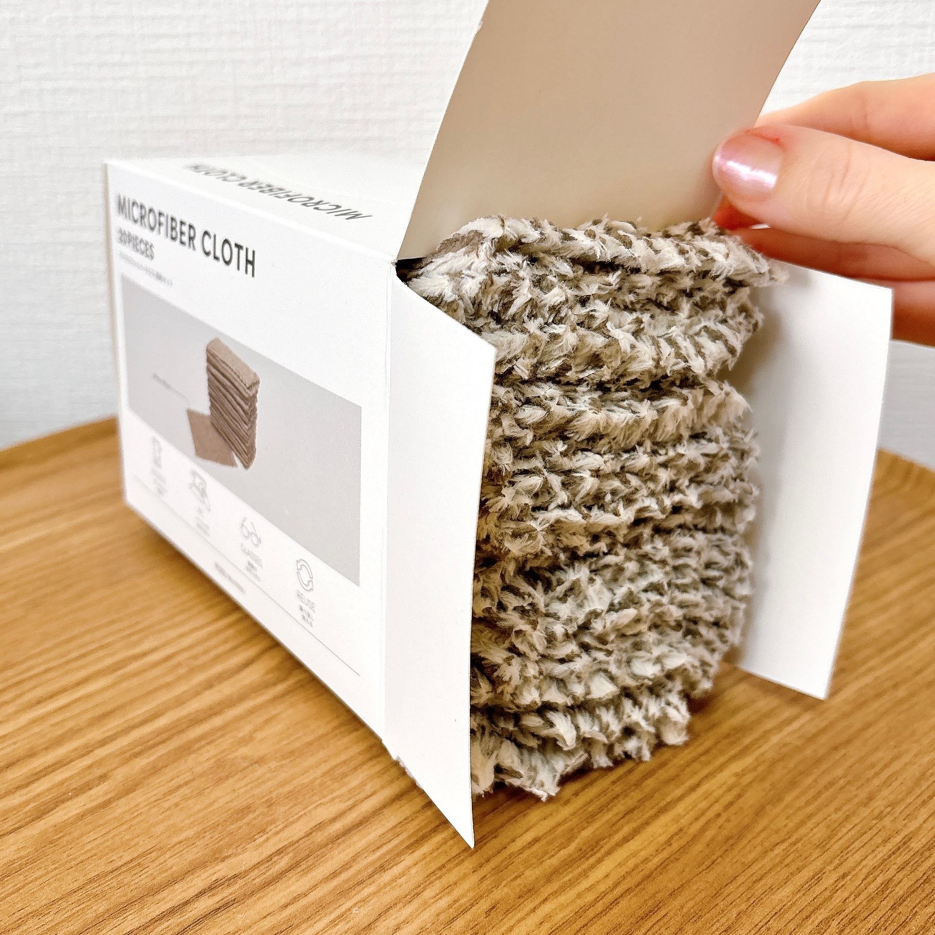 手に持たれたマイクロファイバークロスの箱。クロスが積まれた様子が見える。