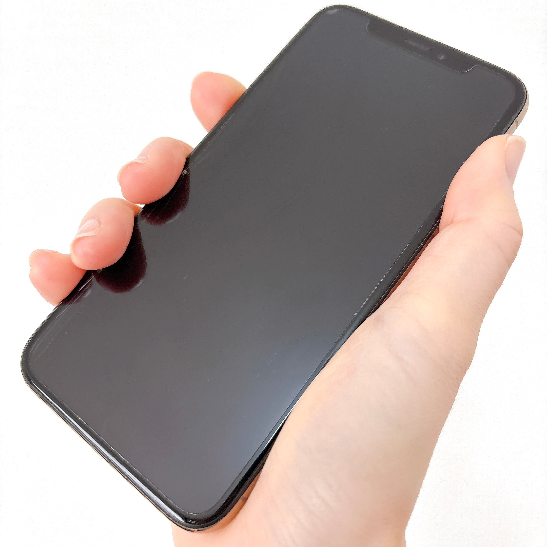 手に持たれたスマートフォンが画面を上にしている様子。