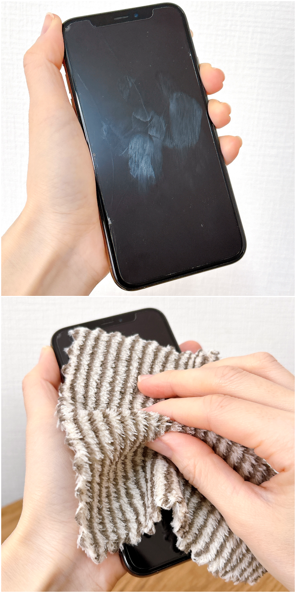 携帯電話を手に持ち、手のひらの跡がついた画面を布でふき取っているところ。