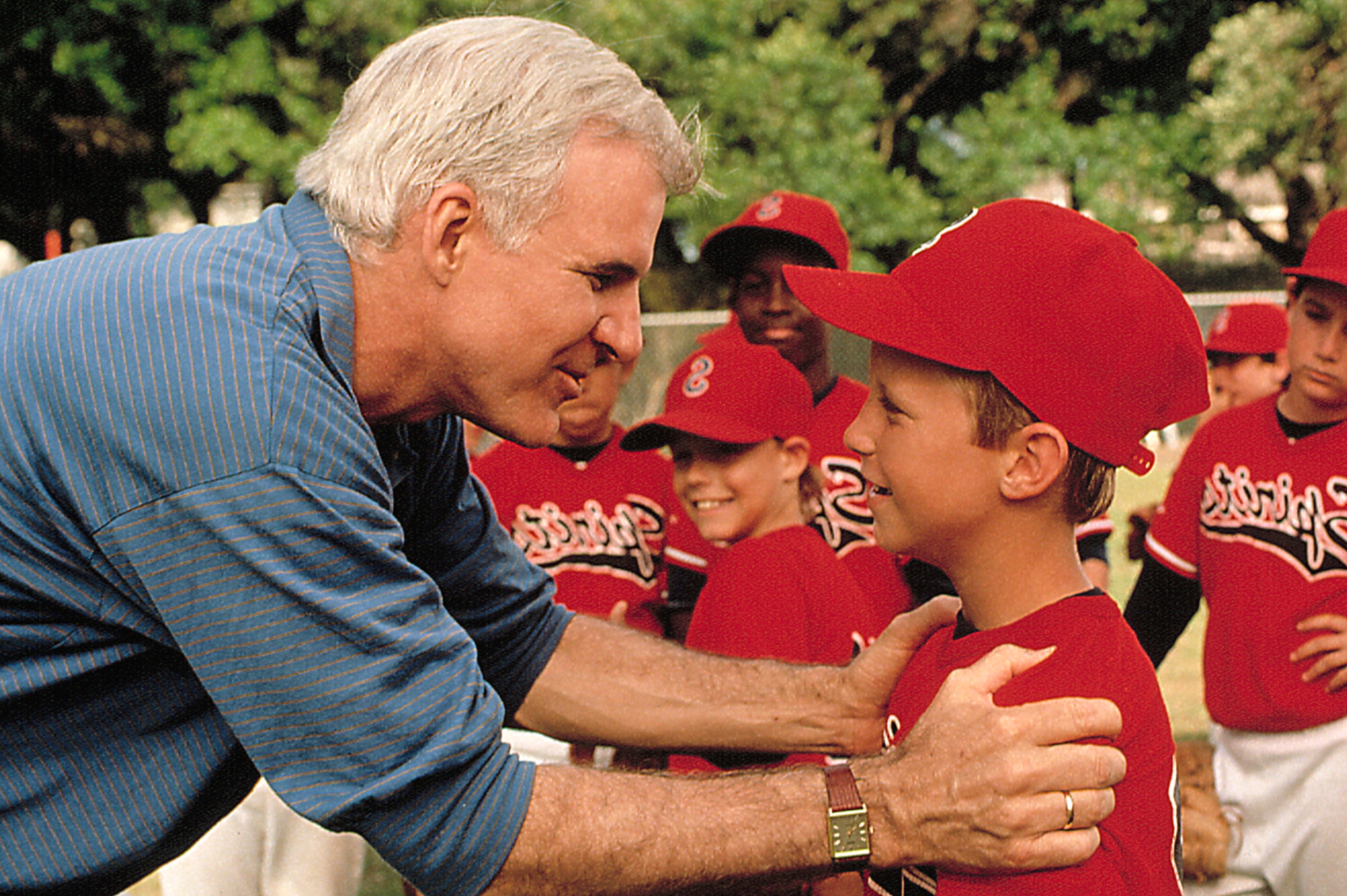 Steve Martin and Jasen Fisher surrounded by kids in baseball uniforms in "Parenthood."