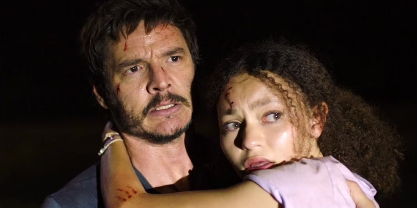 Two individuals with worried expressions in a tense scene from a TV show or movie. One person holds the other protectively
