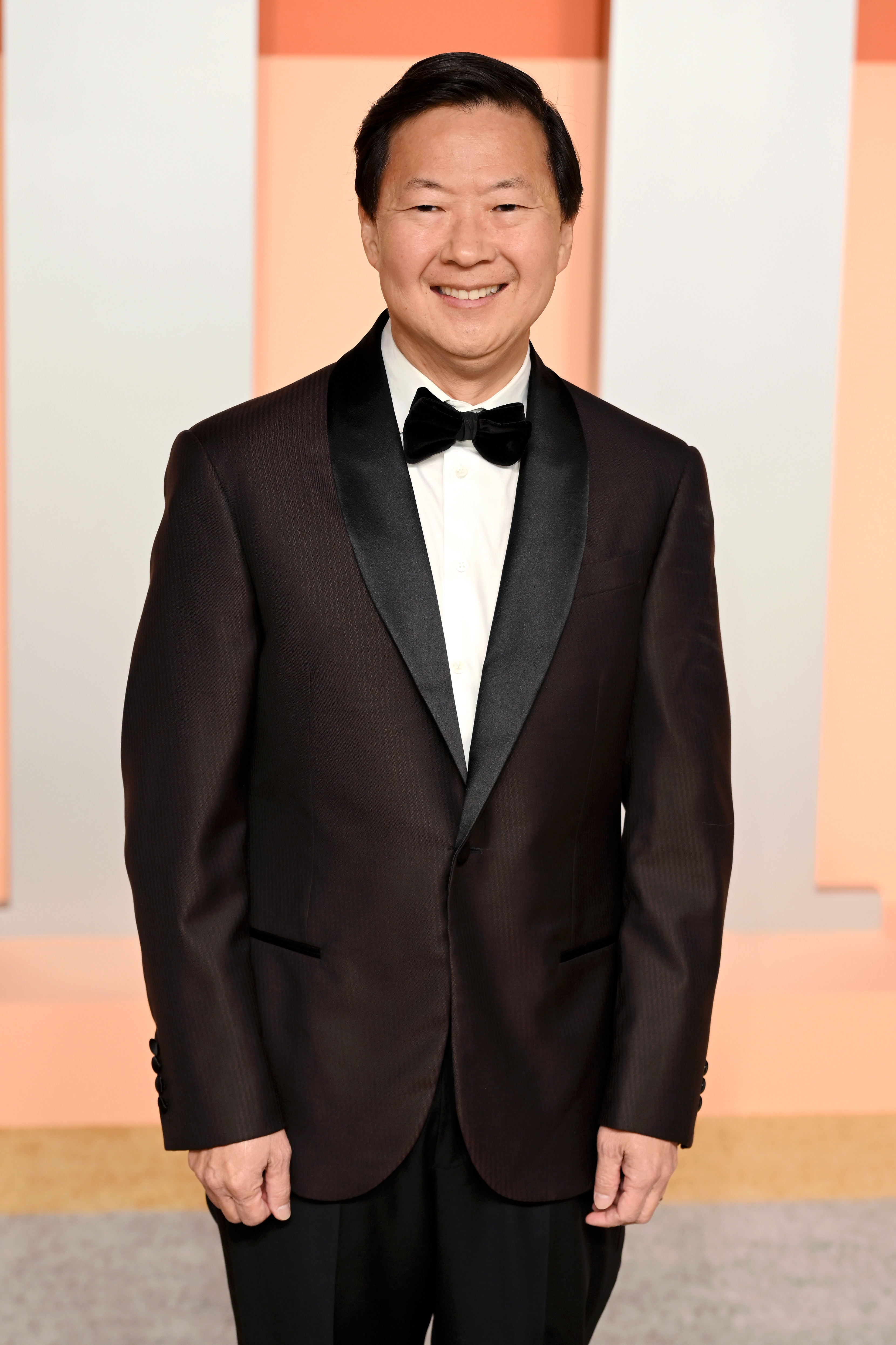 Person in formal suit with bow tie smiling at an event