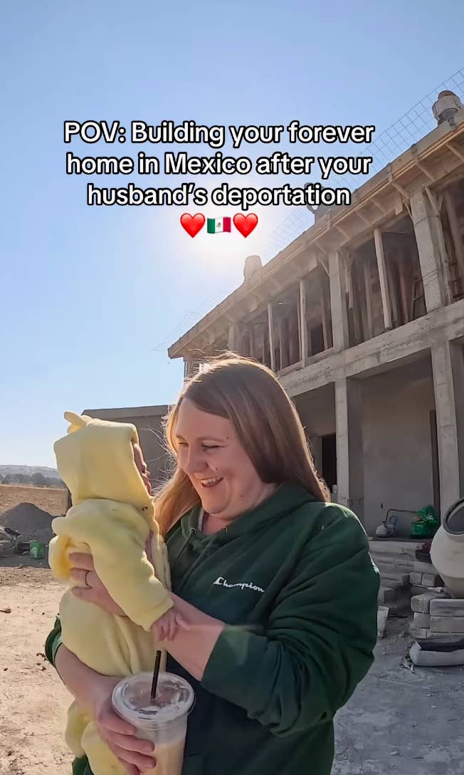 Woman in a green hoodie holds a baby in yellow, standing in front of a house under construction. Text: "POV: Building your forever home in Mexico after your husband's deportation."