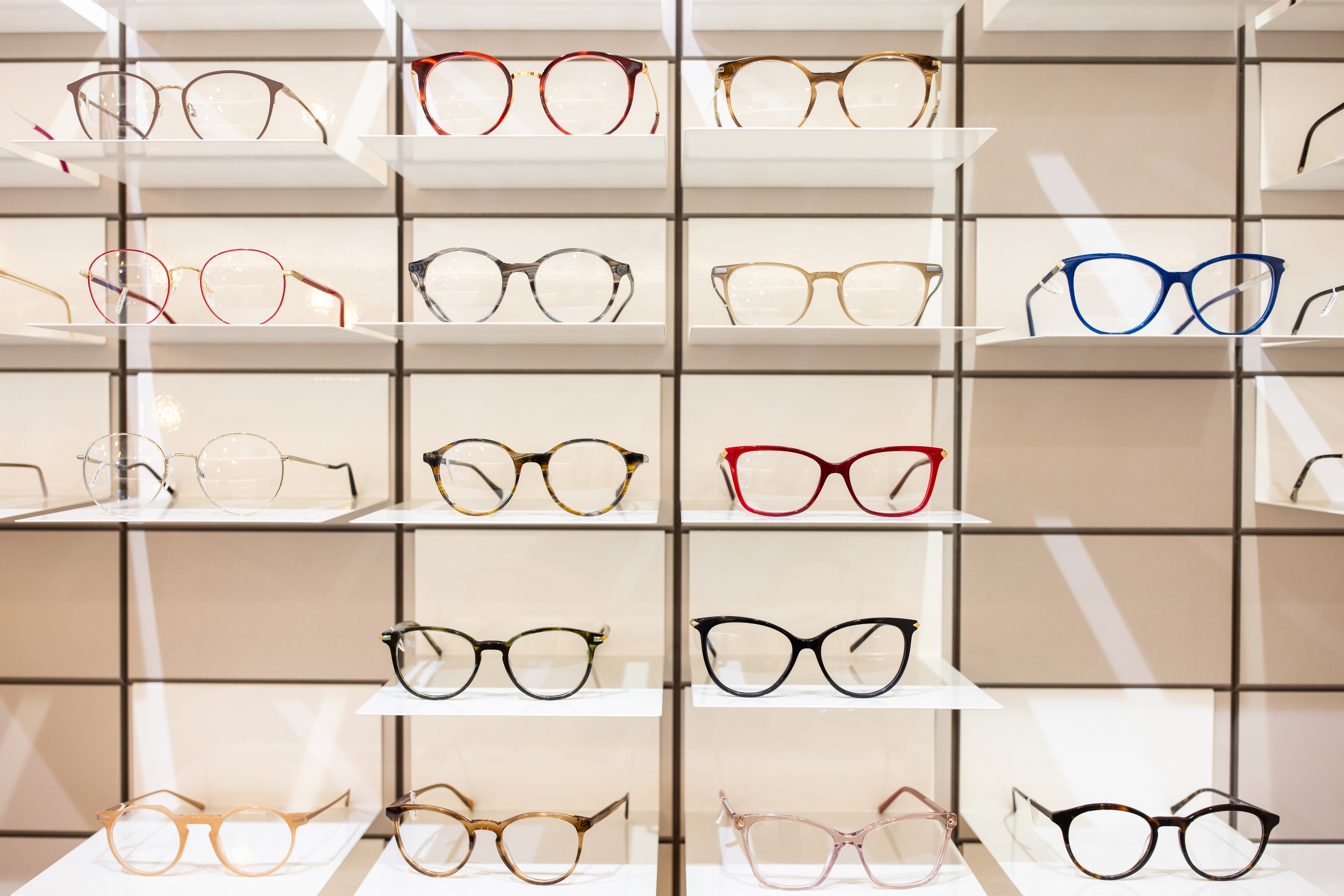 A display of eyeglasses featuring various frame styles and shapes arranged on a shelf.