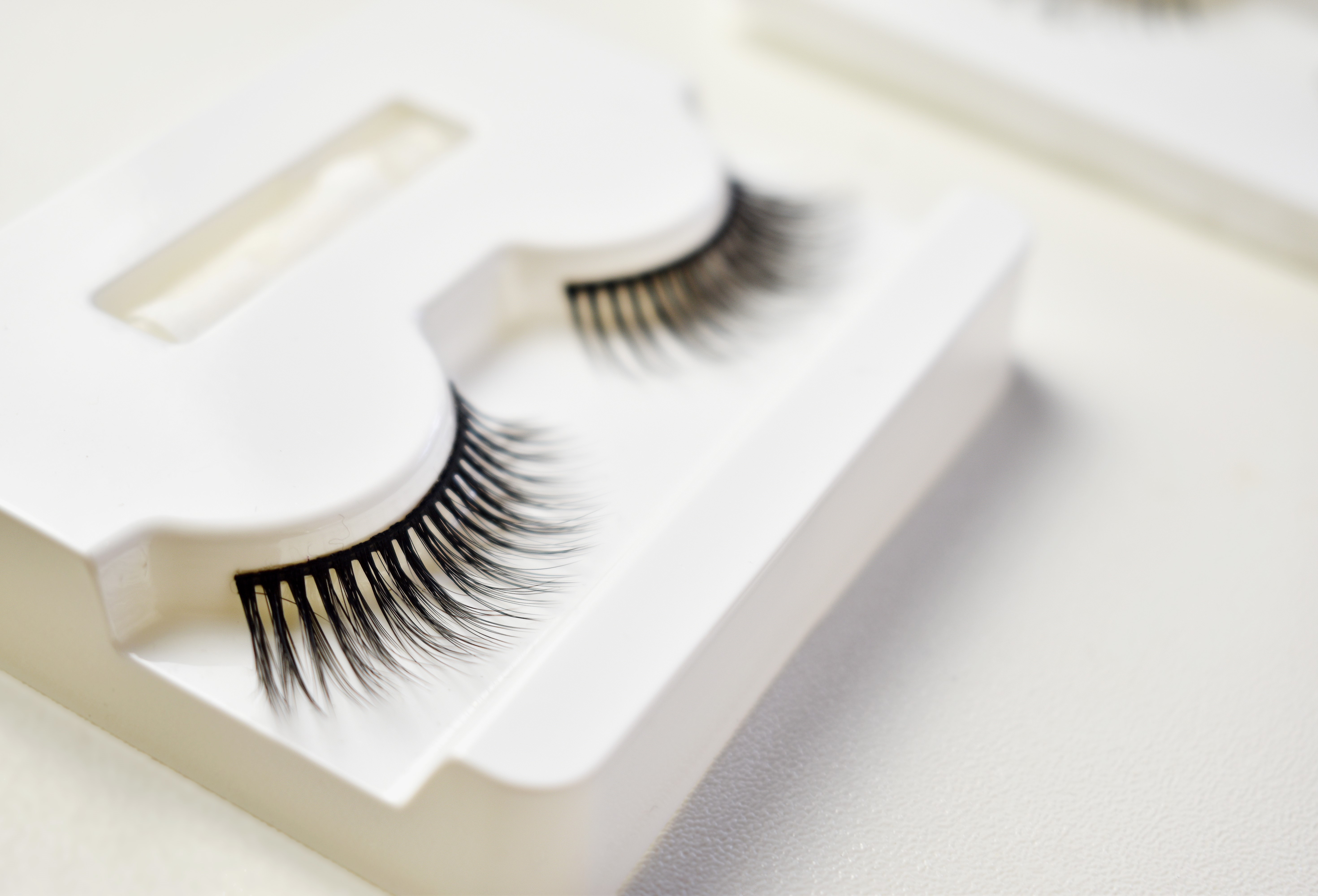 False eyelashes in a white case on a light background.