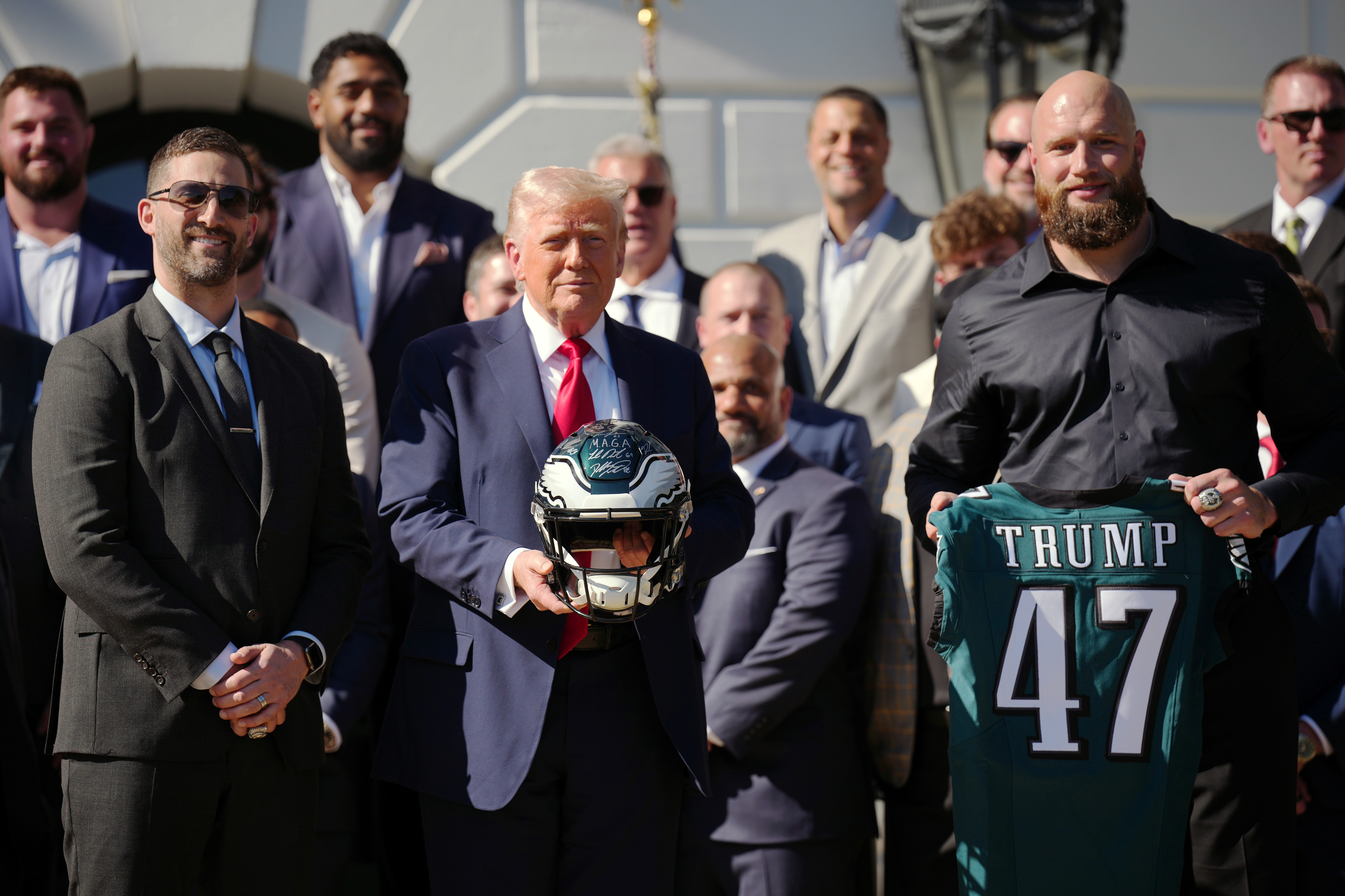 Trump posing with a bunch of Eagles players at an event