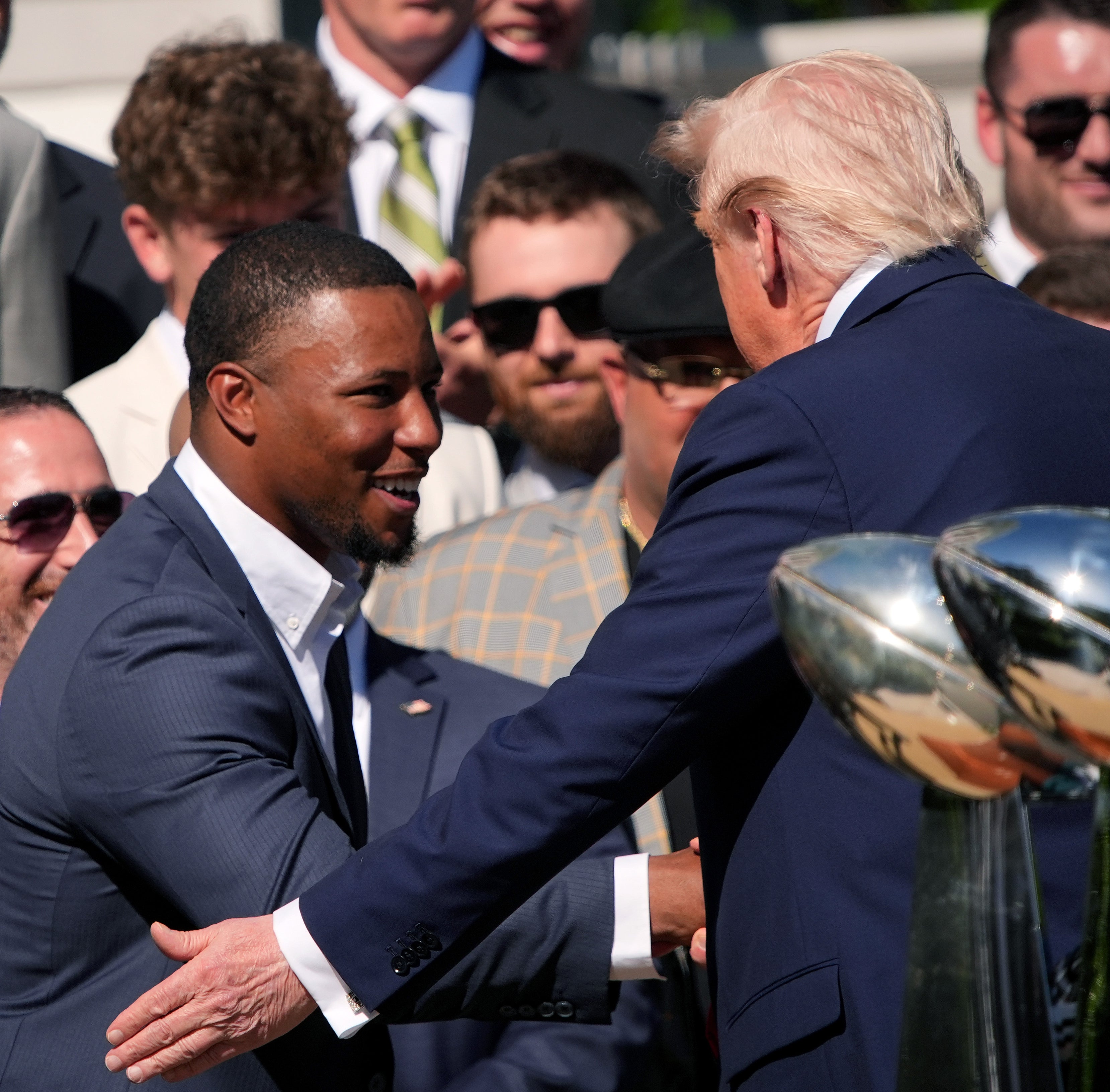 Saquon Barkley shaking hands with Trump at a group event