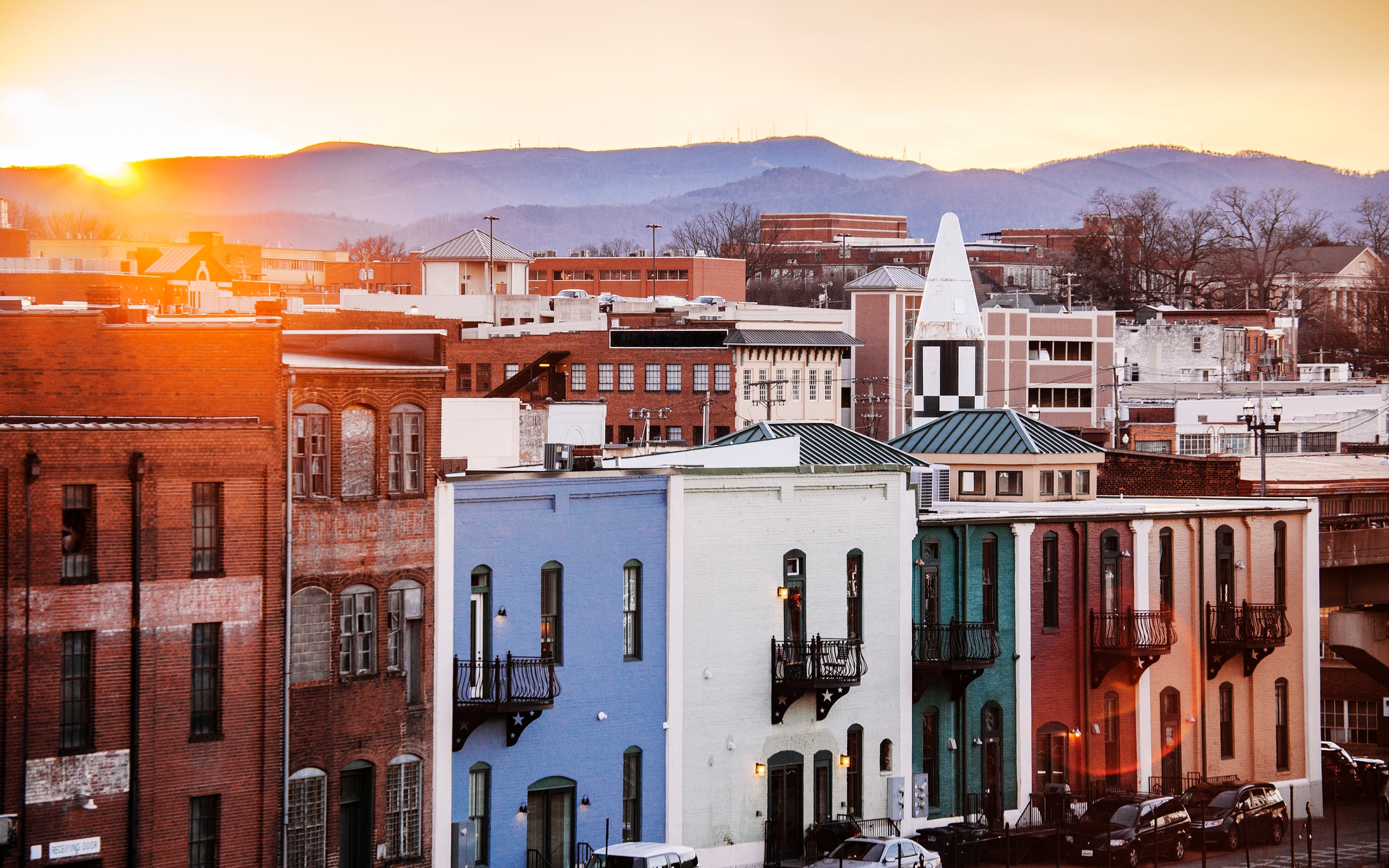 Cityscape with historic buildings at sunset, mountains in background