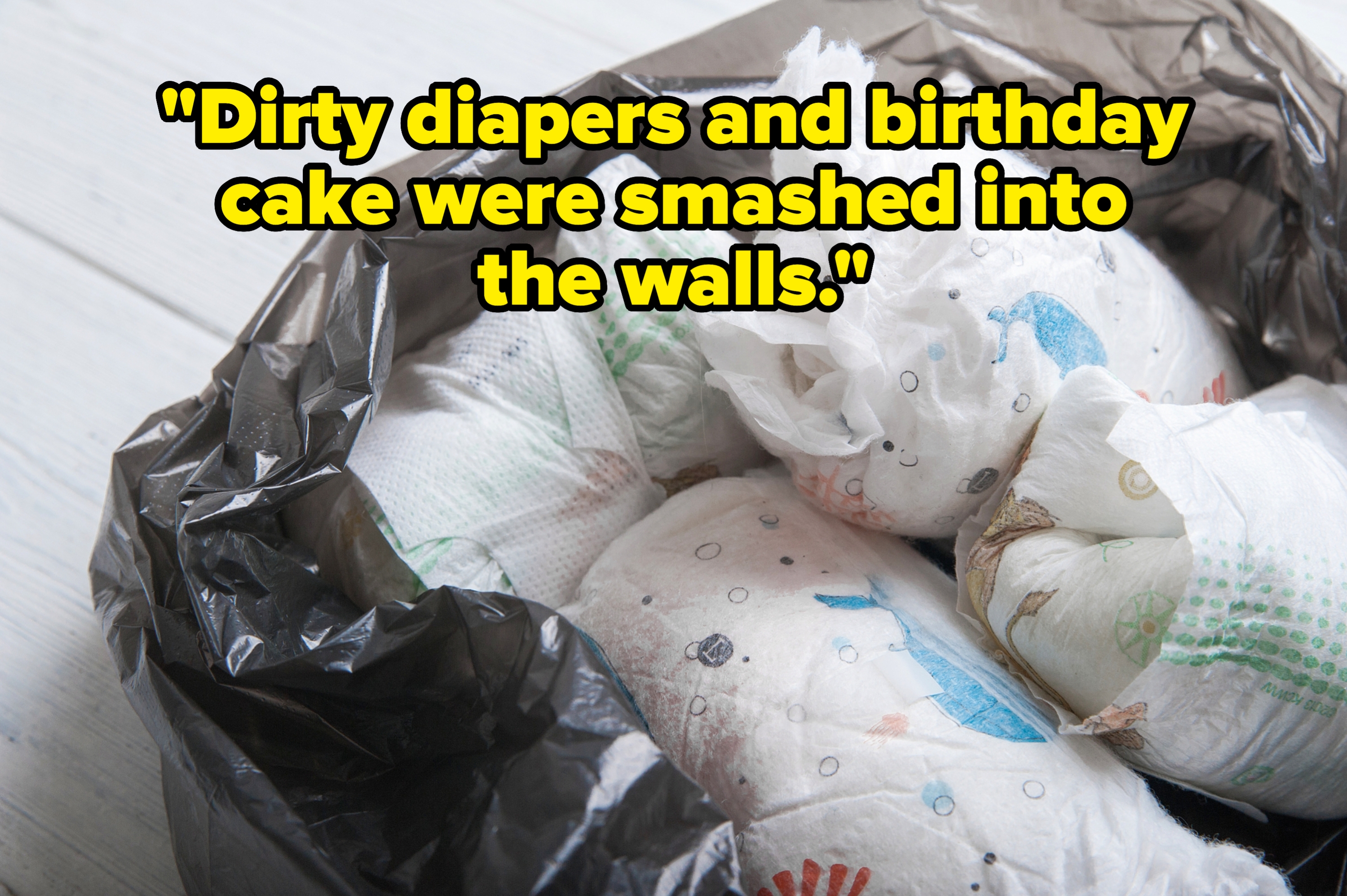 Used diapers in a black trash bag on a wooden floor, suggesting waste disposal or parenting challenges