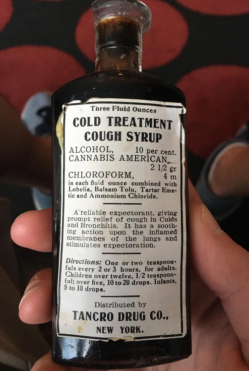 Old bottle labeled "Cold Treatment Cough Syrup" with alcohol, cannabis, and chloroform ingredients