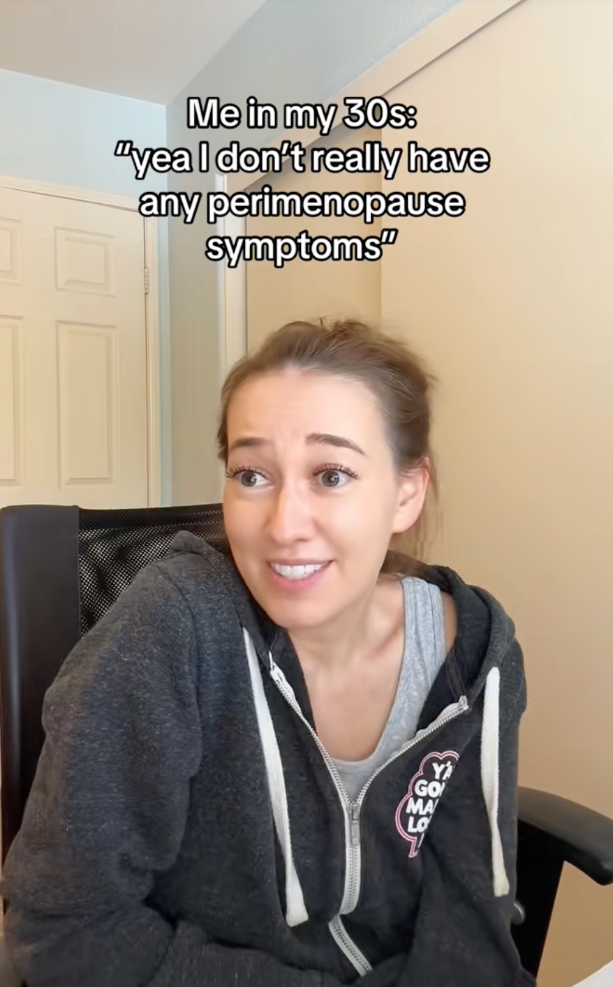 Woman sitting in a chair, looking amused, with text above her about not having perimenopause symptoms in her 30s