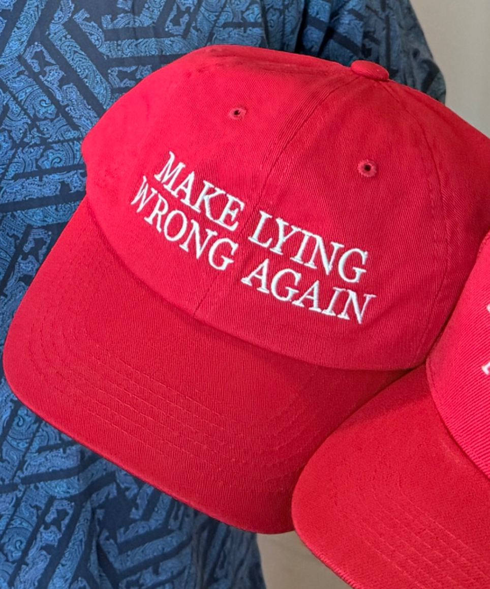 Red baseball cap with the text "MAKE LYING WRONG AGAIN" embroidered in white