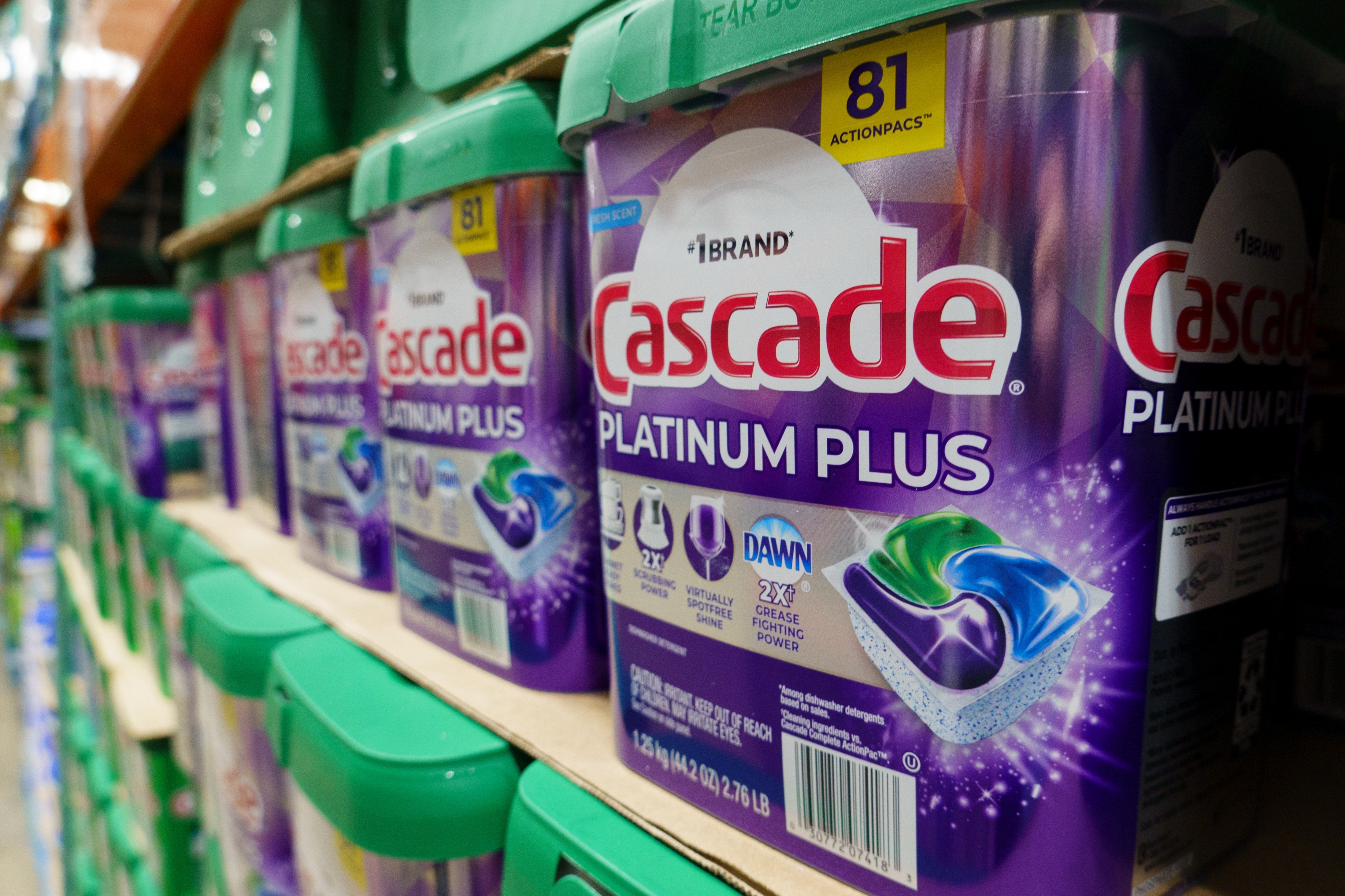 Cascade Platinum Plus dishwasher detergent boxes stacked on a store shelf, highlighting advanced cleaning power
