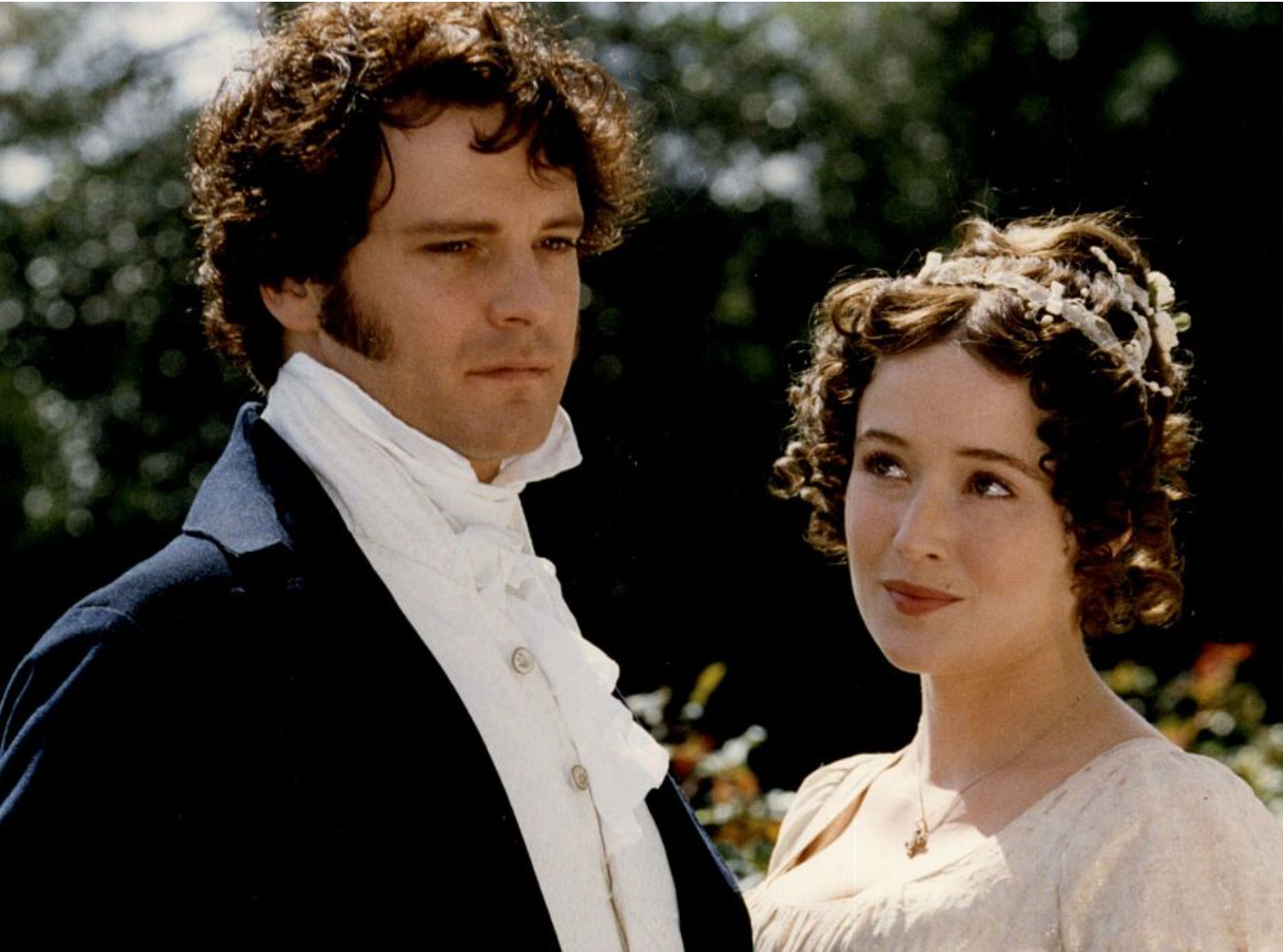 No se puede identificar a las personas en la imagen. Una pareja vestida de época con estilo elegante. Están al aire libre, con expresiones contemplativas