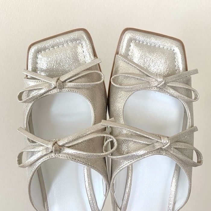 Elegant shoes with square toes, metallic sheen, and bow details on top