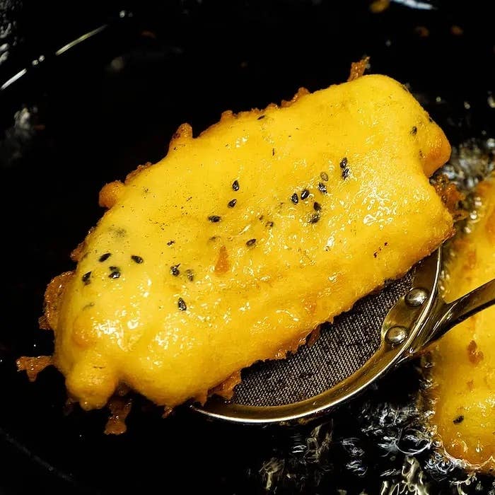 揚げたてのバナナが網の上に乗っている様子。サクサクの衣が特徴的。