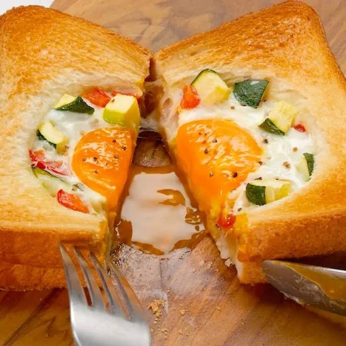 トーストの中央に半熟卵と野菜が入った料理。ナイフとフォークで切り分けられる。