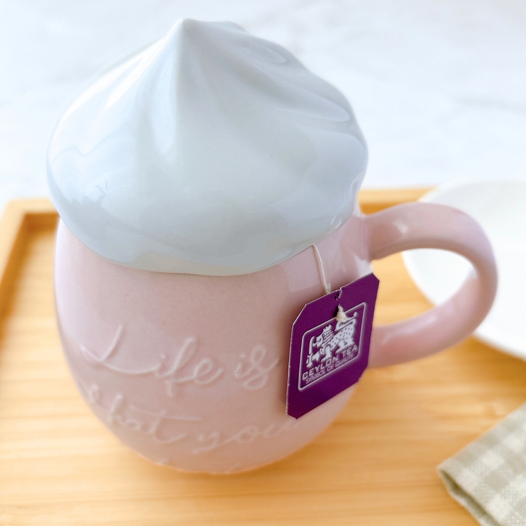 ティーバッグが入ったカップ。カップには「Life is what you make it」と書かれている。おしゃれなデザイン。