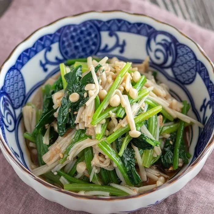 ほうれん草とえのきを使った和風サラダが青い模様の器に盛られている。新鮮な食材が引き立つ一品。