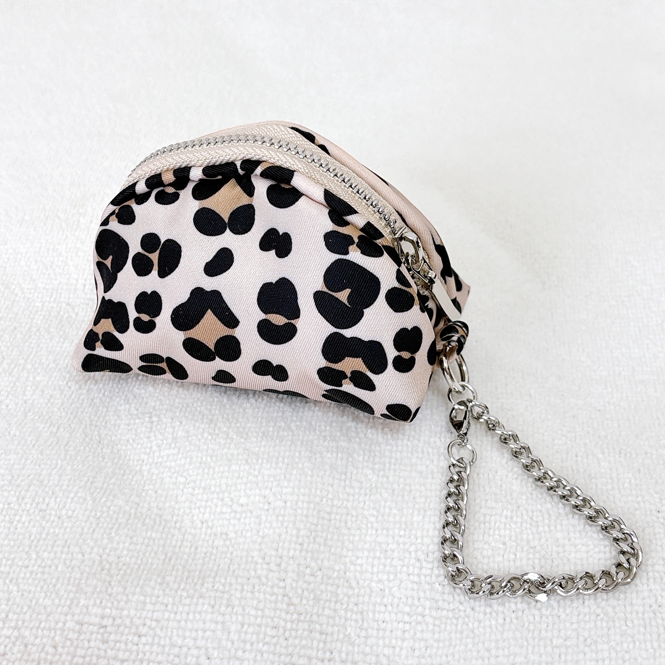 ヒョウ柄の小さなポーチ、チェーンストラップ付き。シンプルでスタイリッシュなアクセサリー。