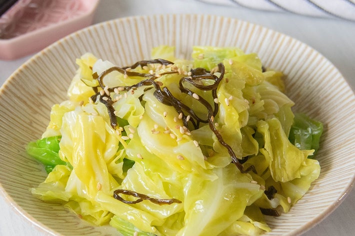 キャベツのサラダ、刻み昆布と白ごまが飾られた料理。