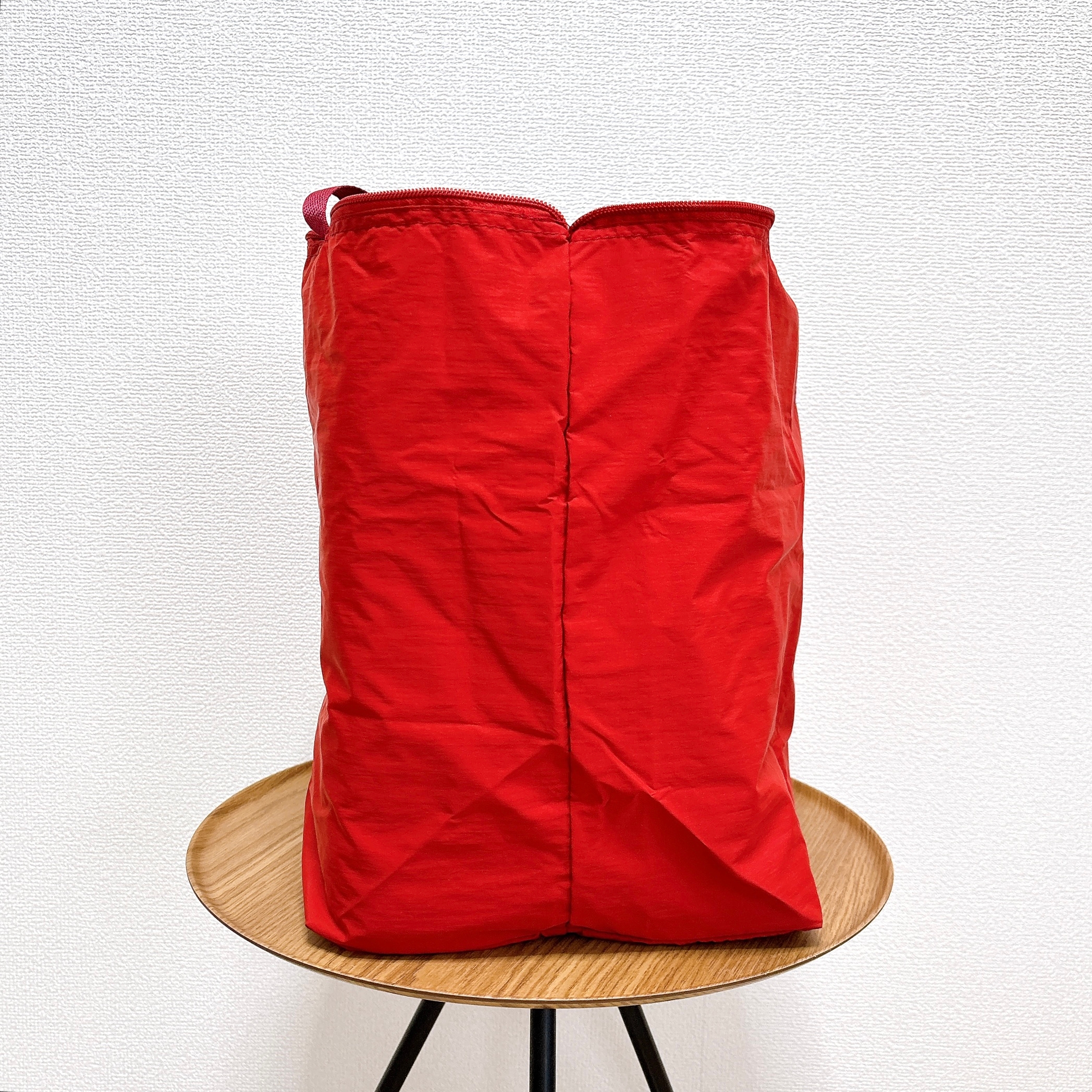 赤い袋が丸い木製のテーブルの上に立っている。