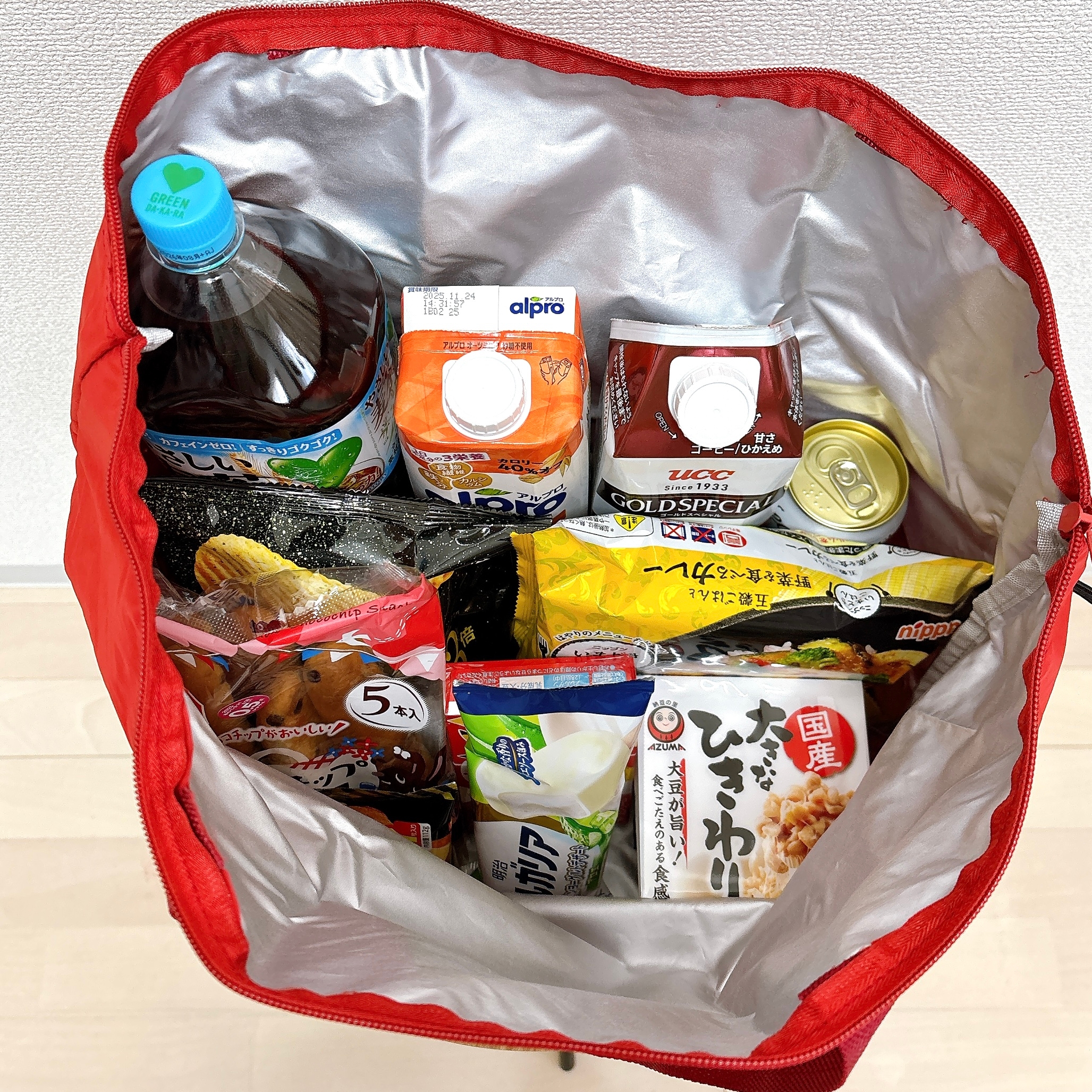 バッグの中に飲み物とお菓子、インスタント食品が詰められている様子。買い物帰りのシーン。