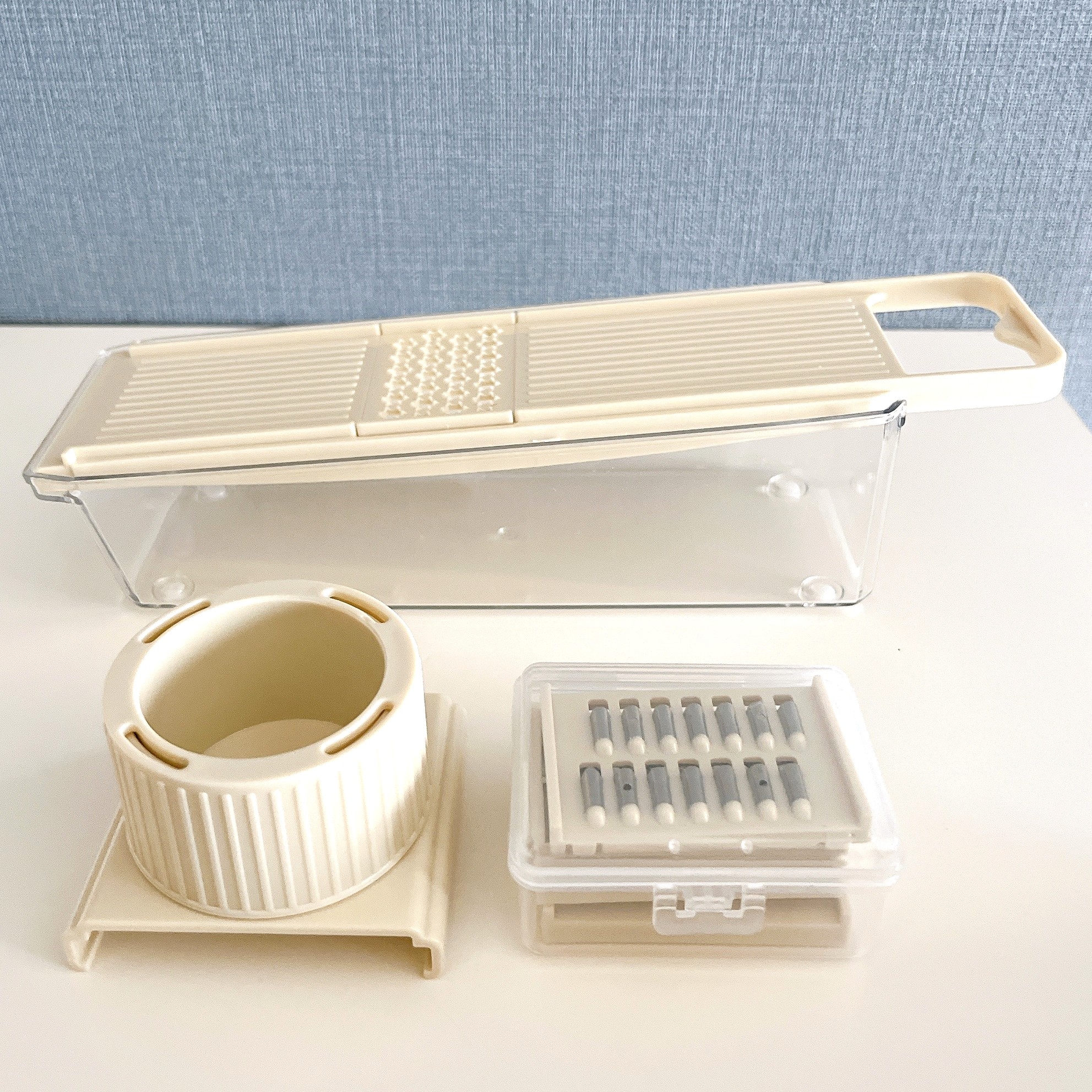 スライサー付きの調理用キッチンツールと付属品がテーブルの上に配置されています。