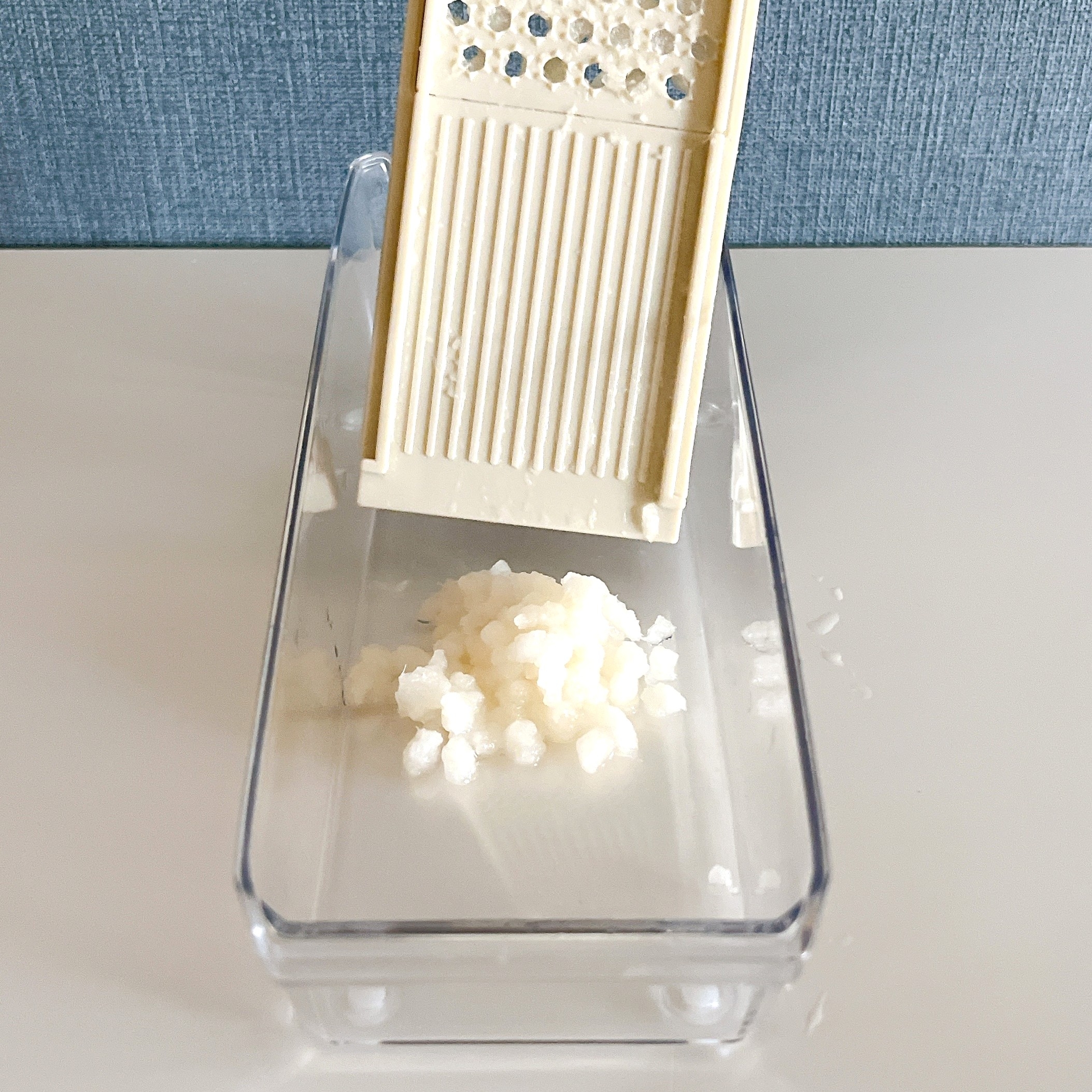 おろし金で大根おろしを作っている様子。ボウルにおろされた大根が集まっている。