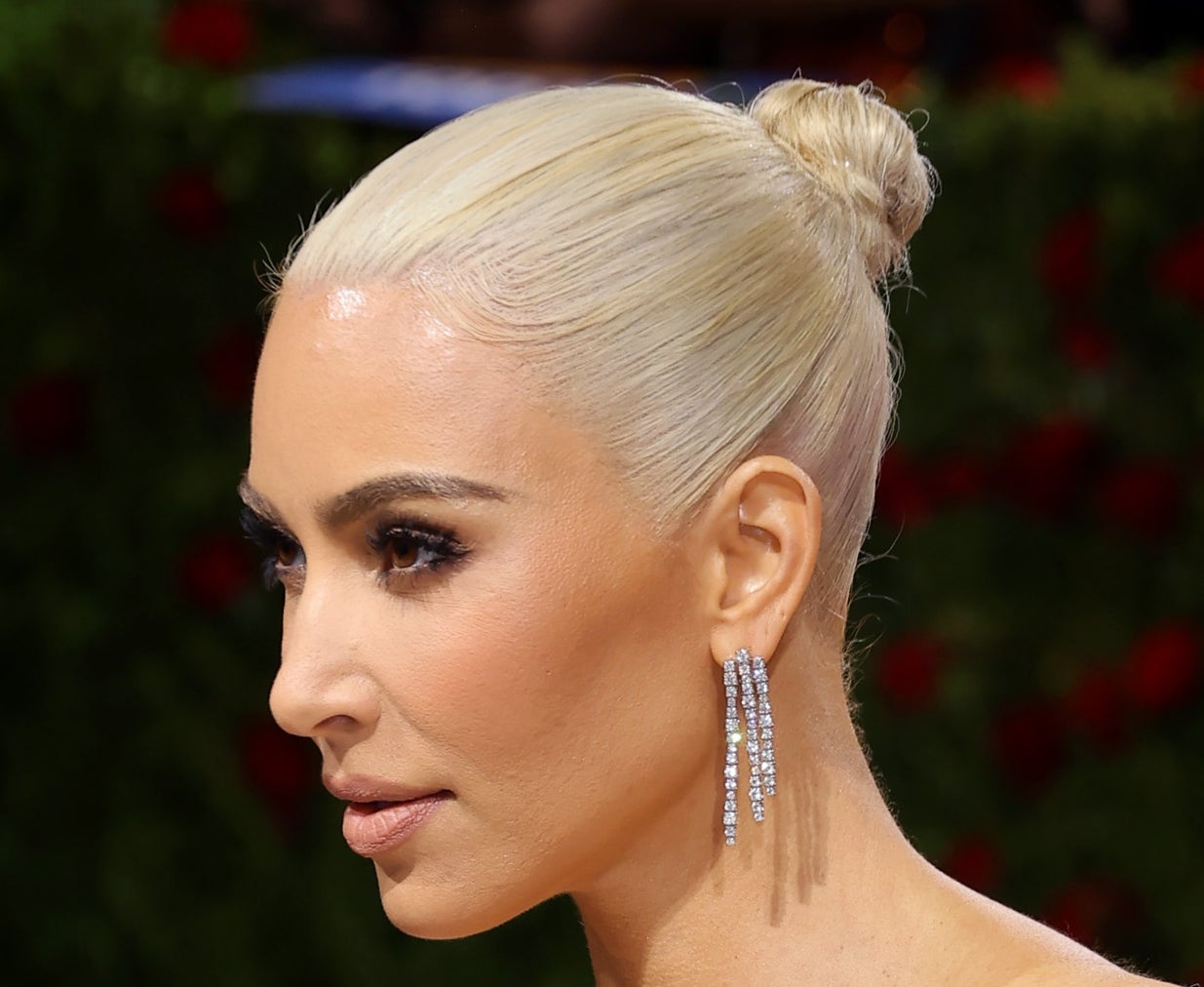 Kim with platinum hair in a tight bun, some of it yellow and streaky