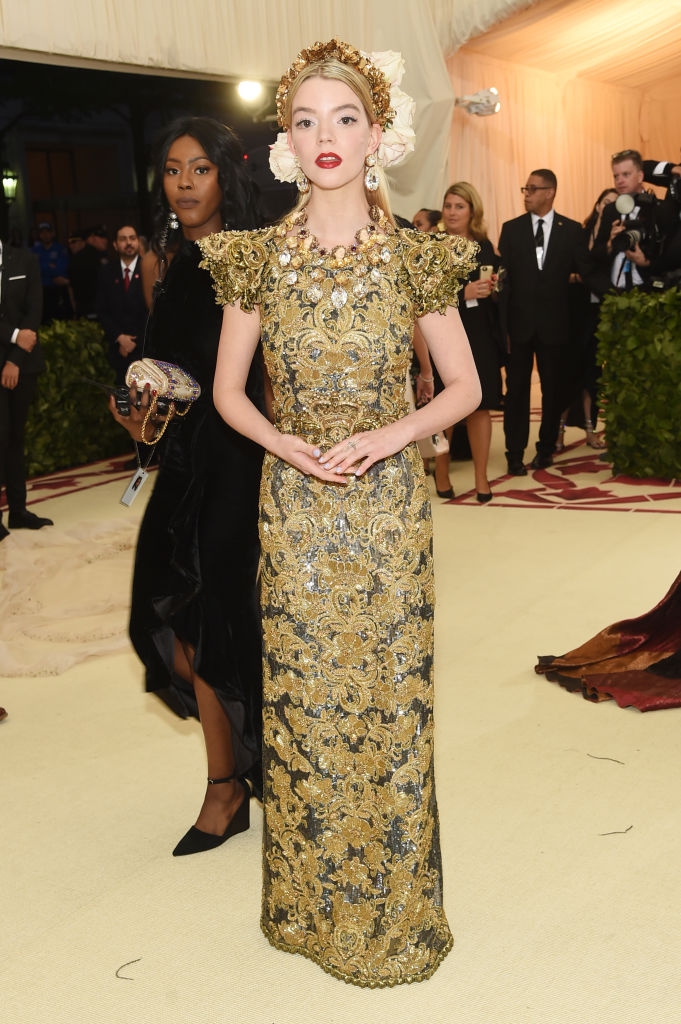 Anya in an ornate gold dress with detailed floral patterns and headpiece