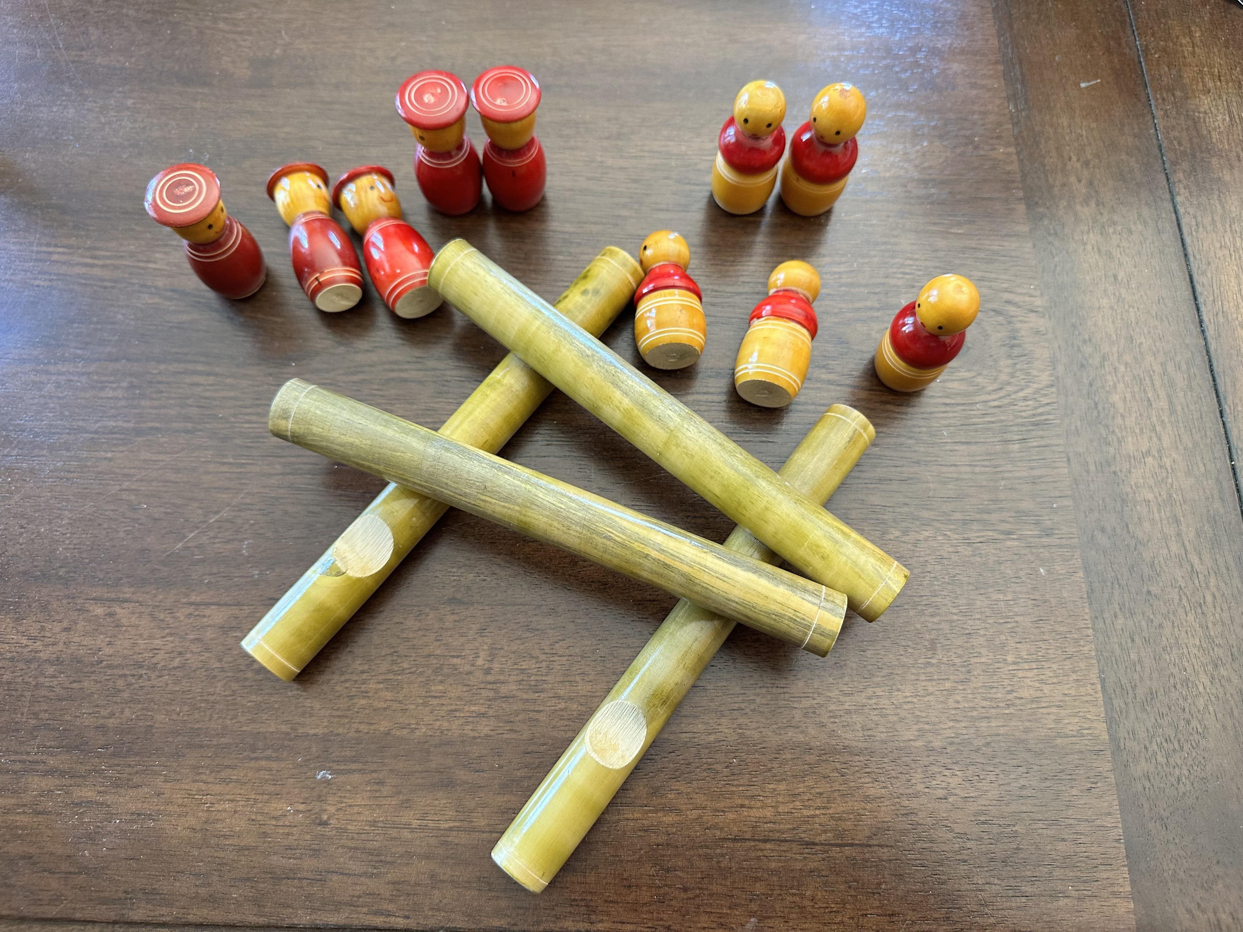 Wooden tabletop game pieces and pin setup on a wooden surface