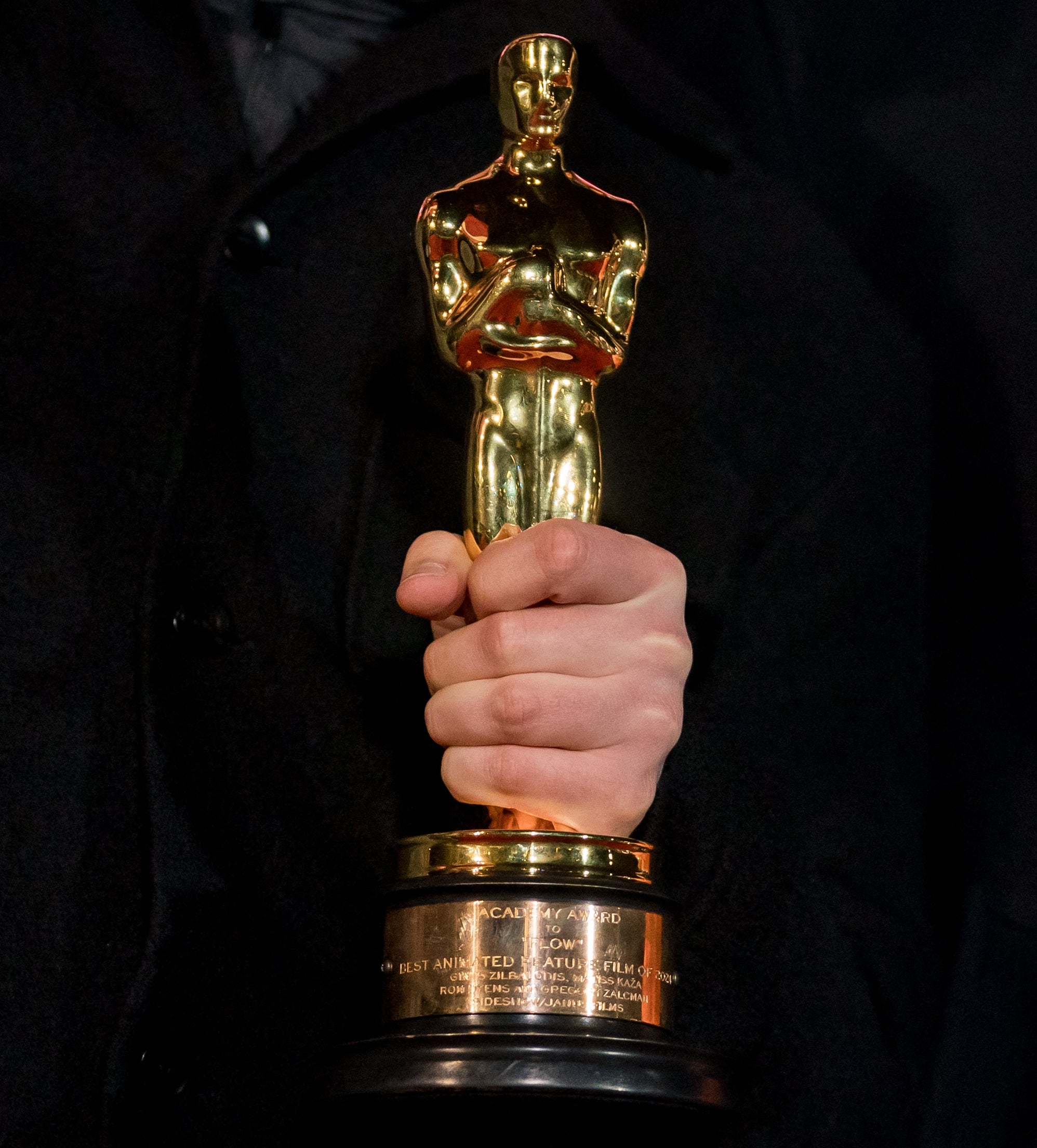 Close up of a hand holding an Oscar statuette