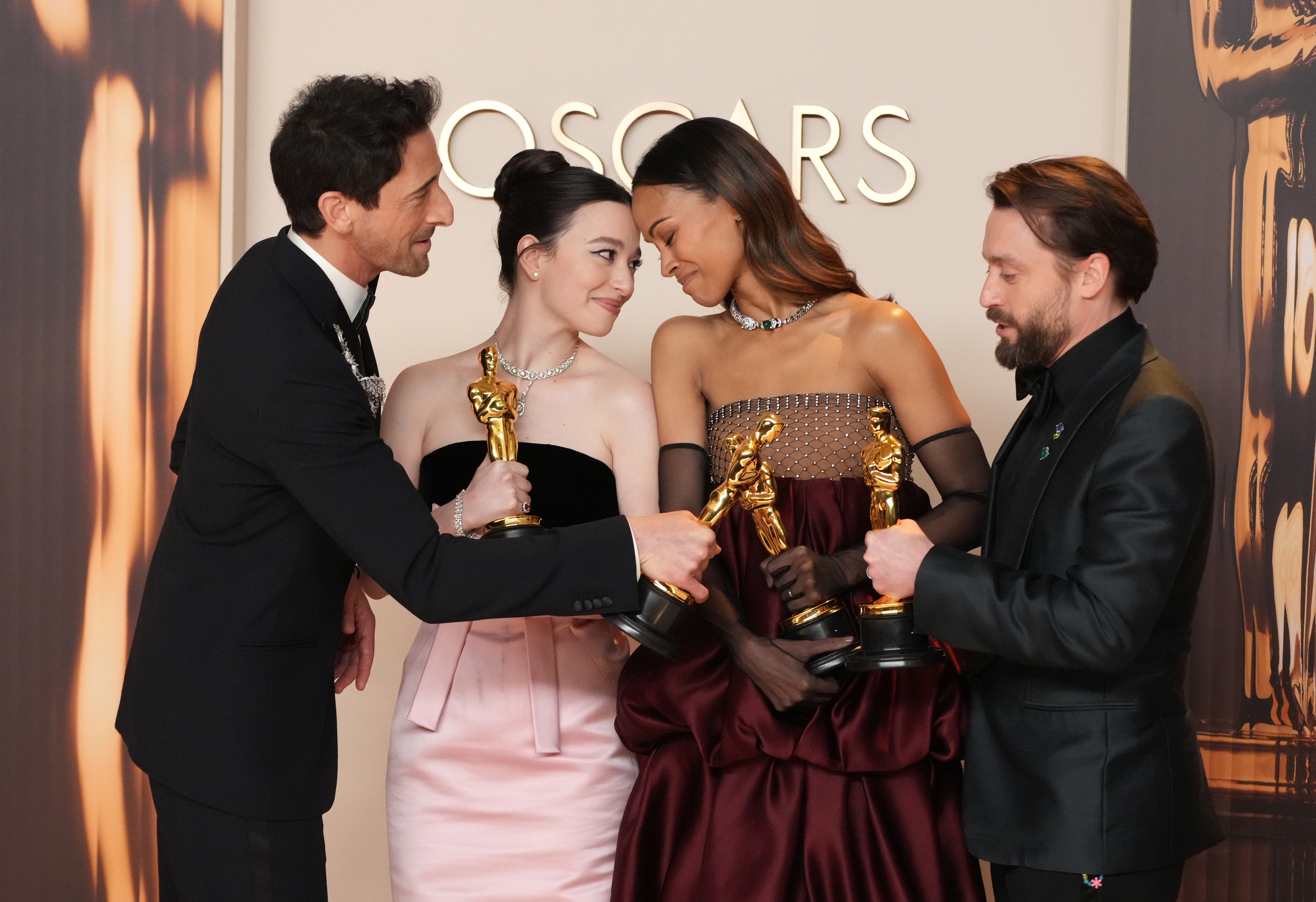 Adrien Brody, Mikey Madison, Zoe Saldaña, and Kieran Culkin holding Oscar trophies