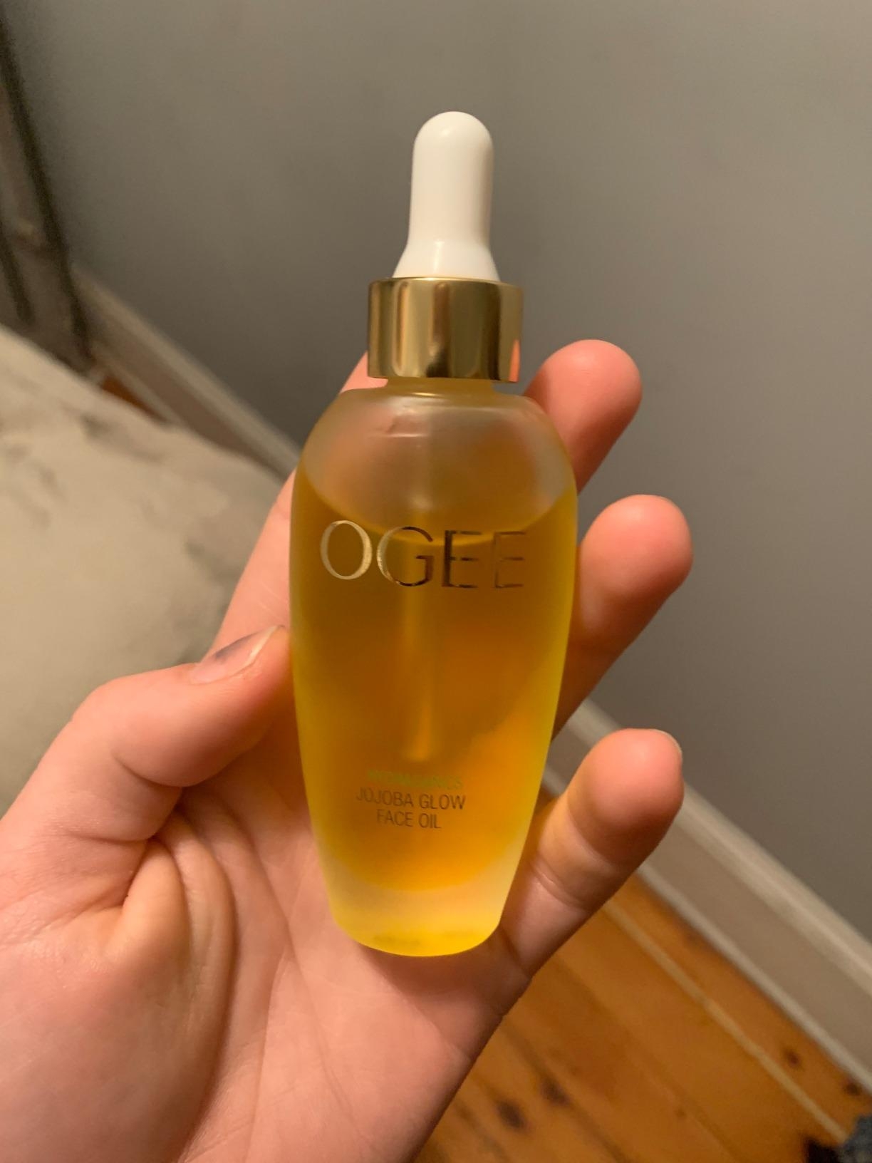 reviewer holding a bottle of Ogee Jojoba Glow Face Oil with a dropper lid