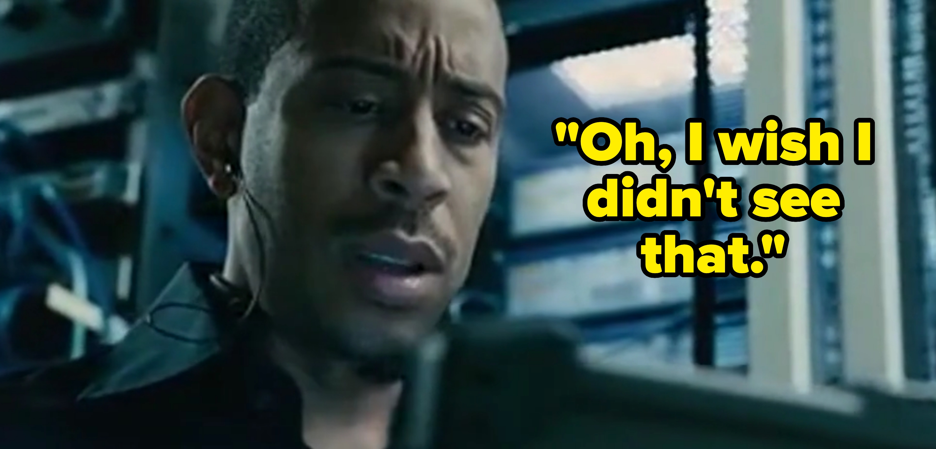 A person looks intently at a screen, surrounded by electronic equipment, appearing focused and engaged in a high-tech environment