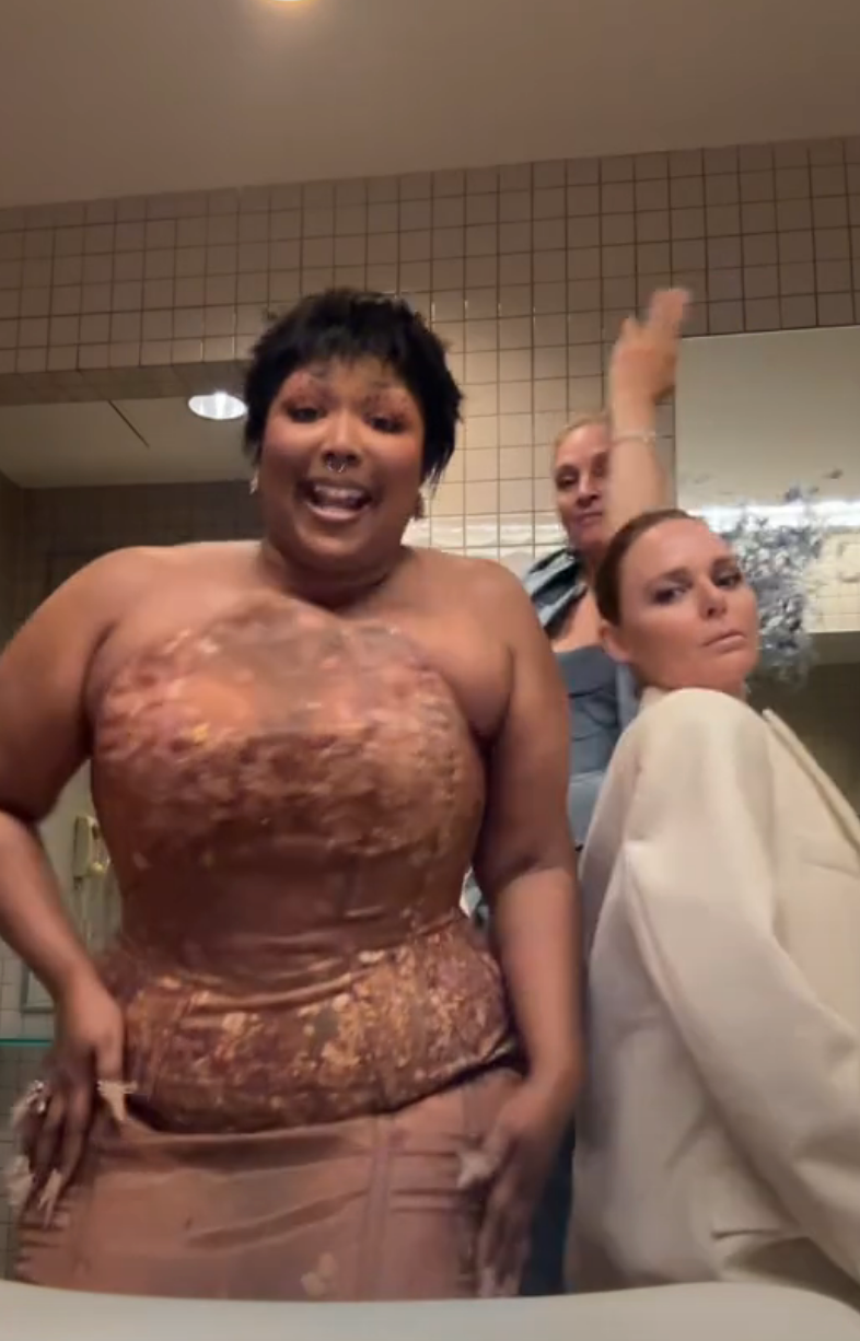 Lizzo, Uma, and Stella in glamorous outfits, dancing in front of the sink