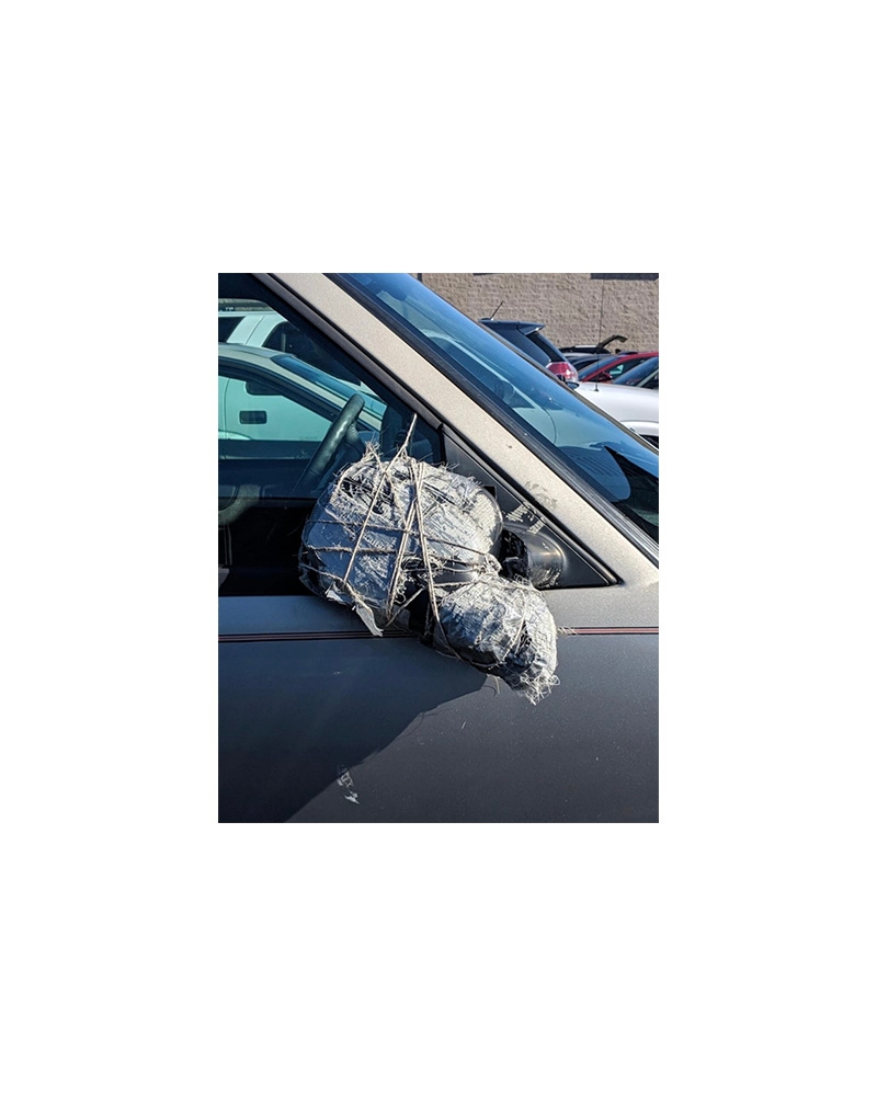 Car side mirror replaced with a makeshift bundle of duct tape and metal rods