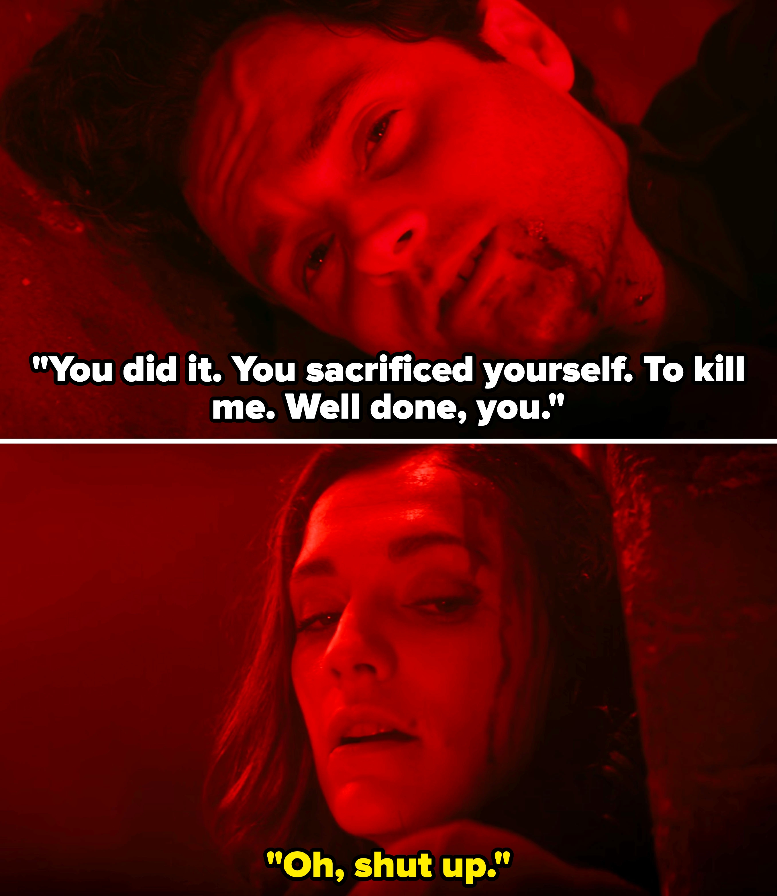 A man and a woman lie on the ground, appearing injured and looking intently at each other, in a dramatic red-lit scene