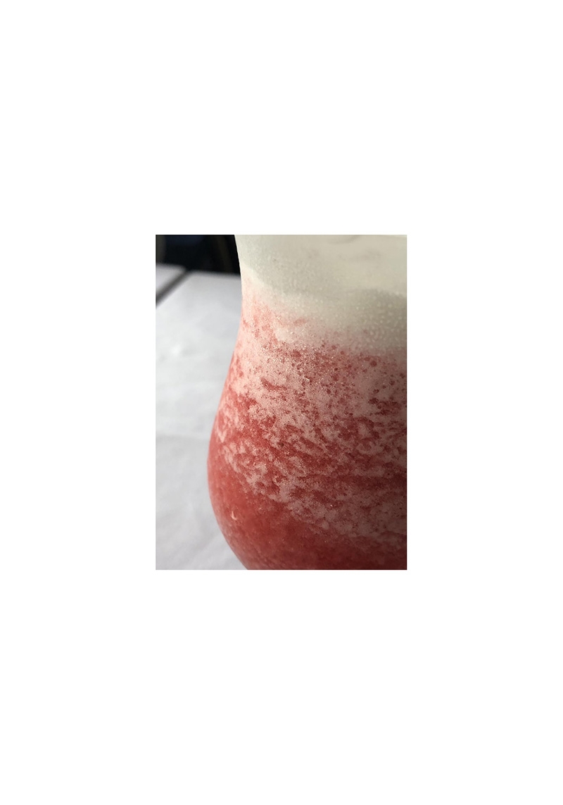 Close-up of a layered frozen drink with red and white sections, texture visible